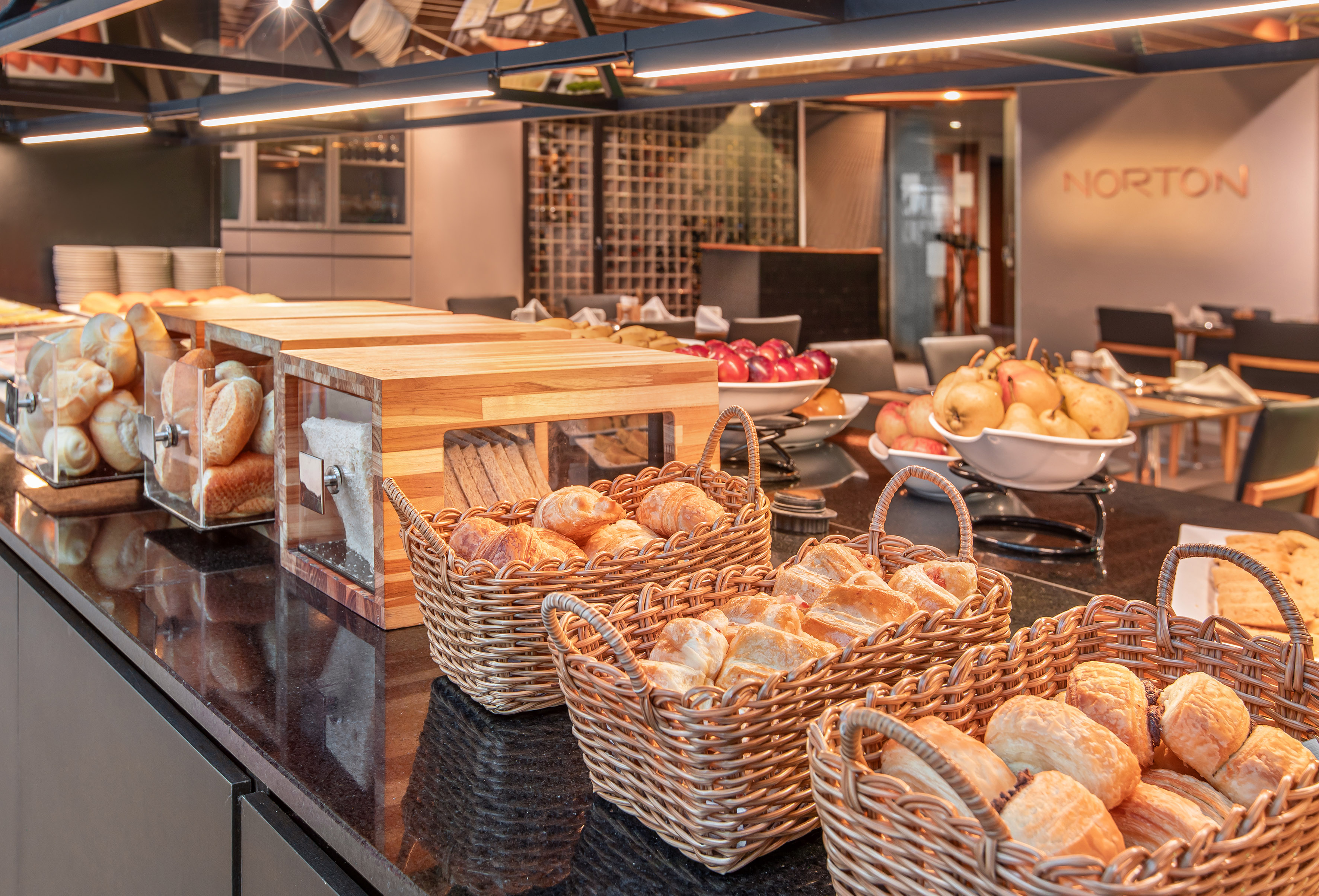 Fresh bread, croissants, and fruit at a hotel breakfast buffet.