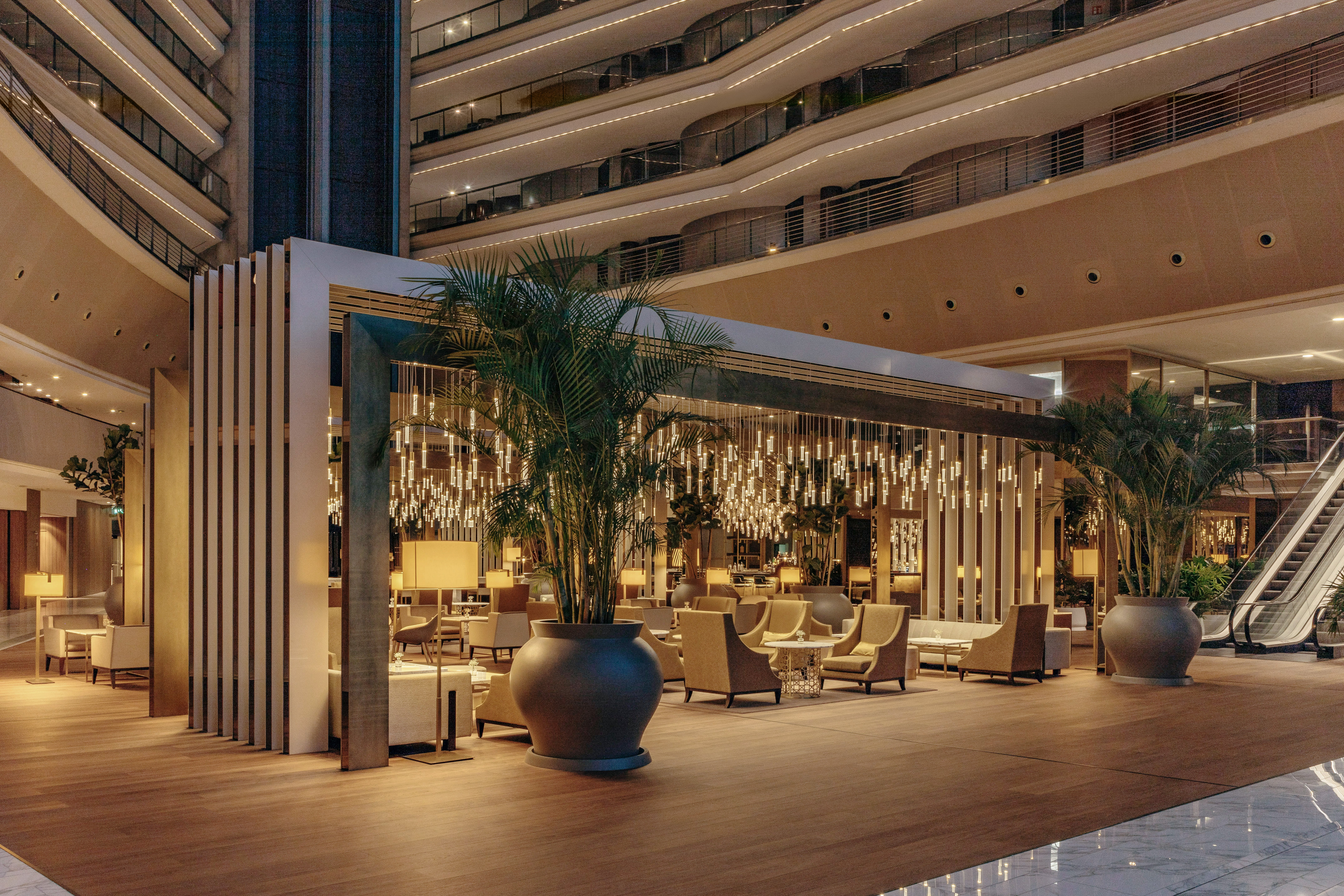 Modern hotel atrium lounge with stylish seating and unique lighting.