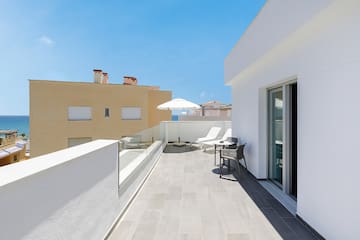 a patio with chairs and umbrella on a roof