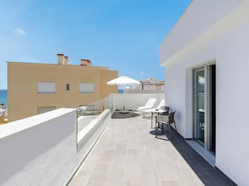 a patio with chairs and umbrella on a roof