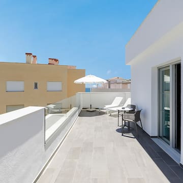 a patio with chairs and umbrella on a roof