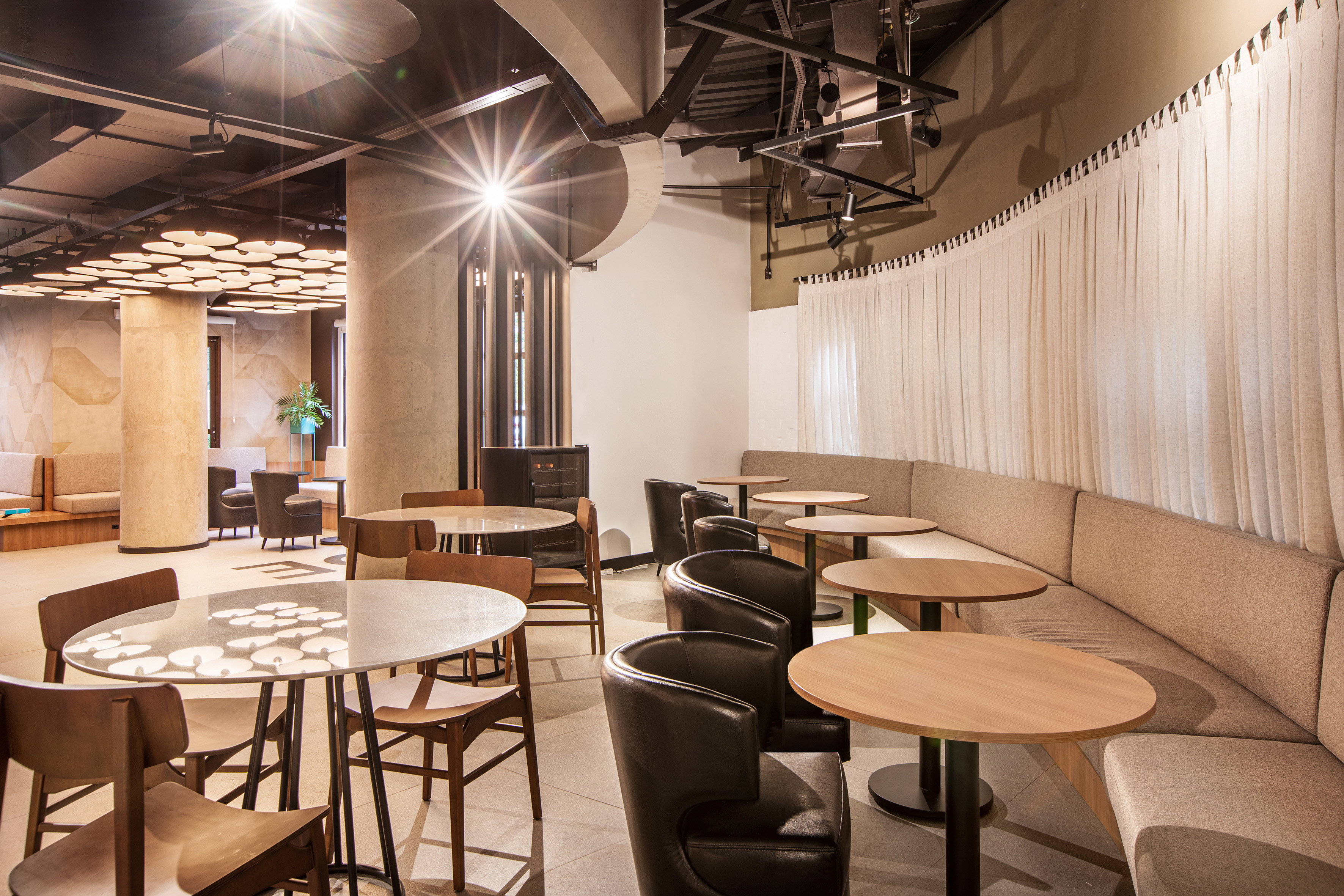 Modern cafe interior with diverse seating options and stylish lighting.