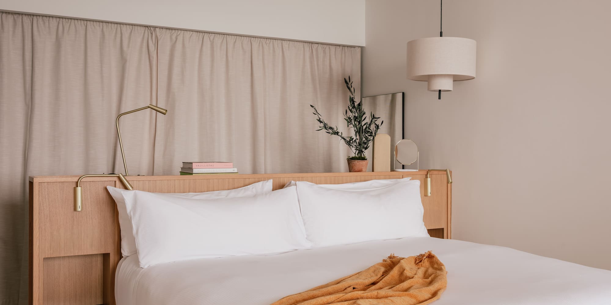 a bed with white sheets and a lamp