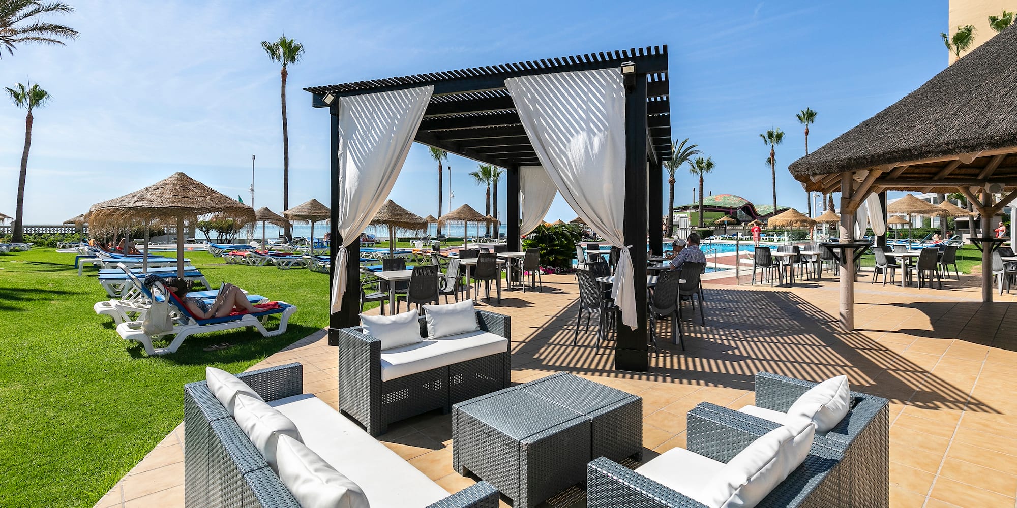a pool with a gazebo and chairs