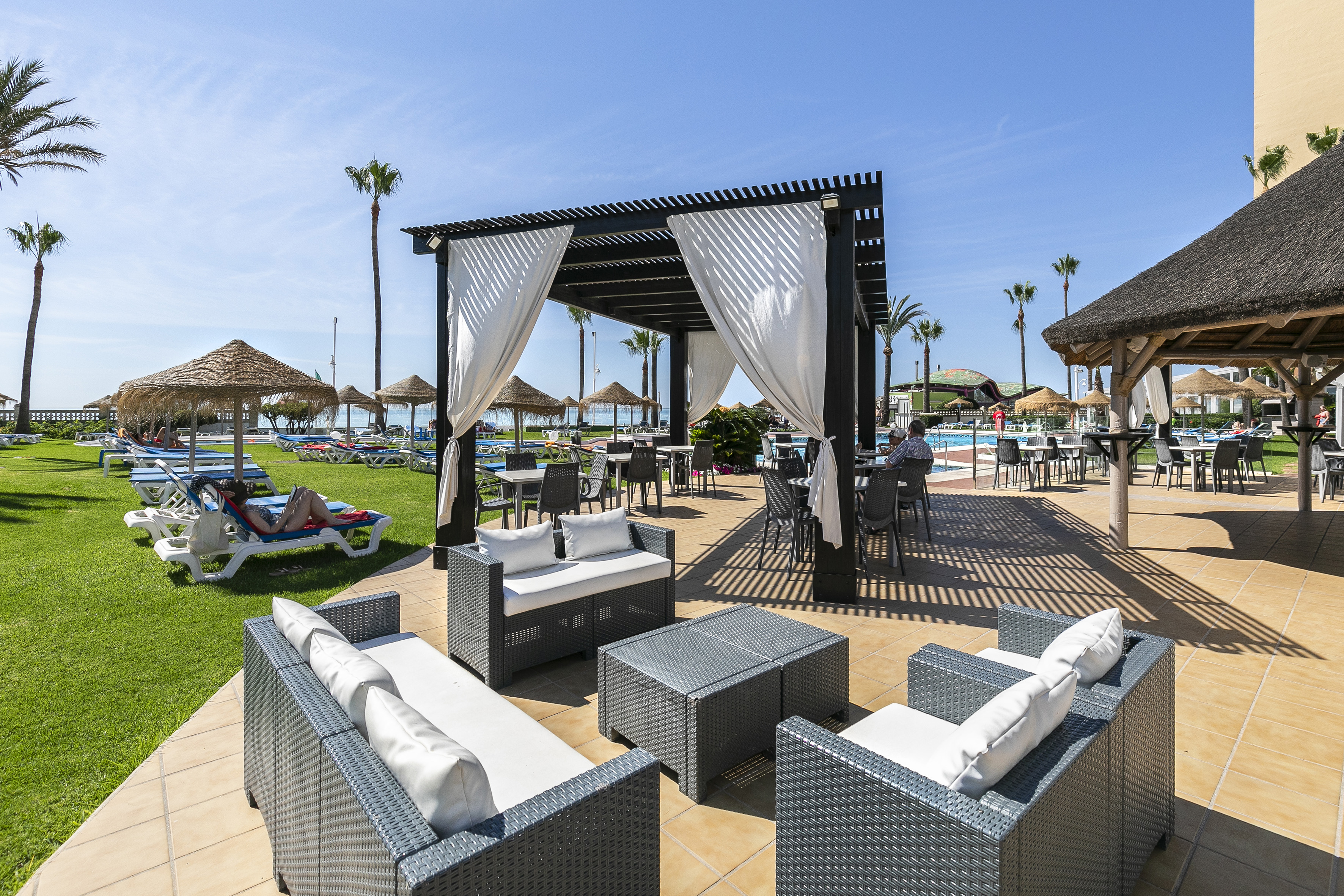 a pool with a gazebo and chairs