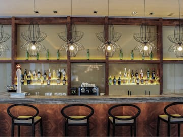 a bar with bottles of liquor and chairs