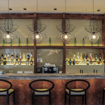 a bar with bottles of liquor and chairs