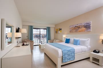 a room with a bed and a table and chairs