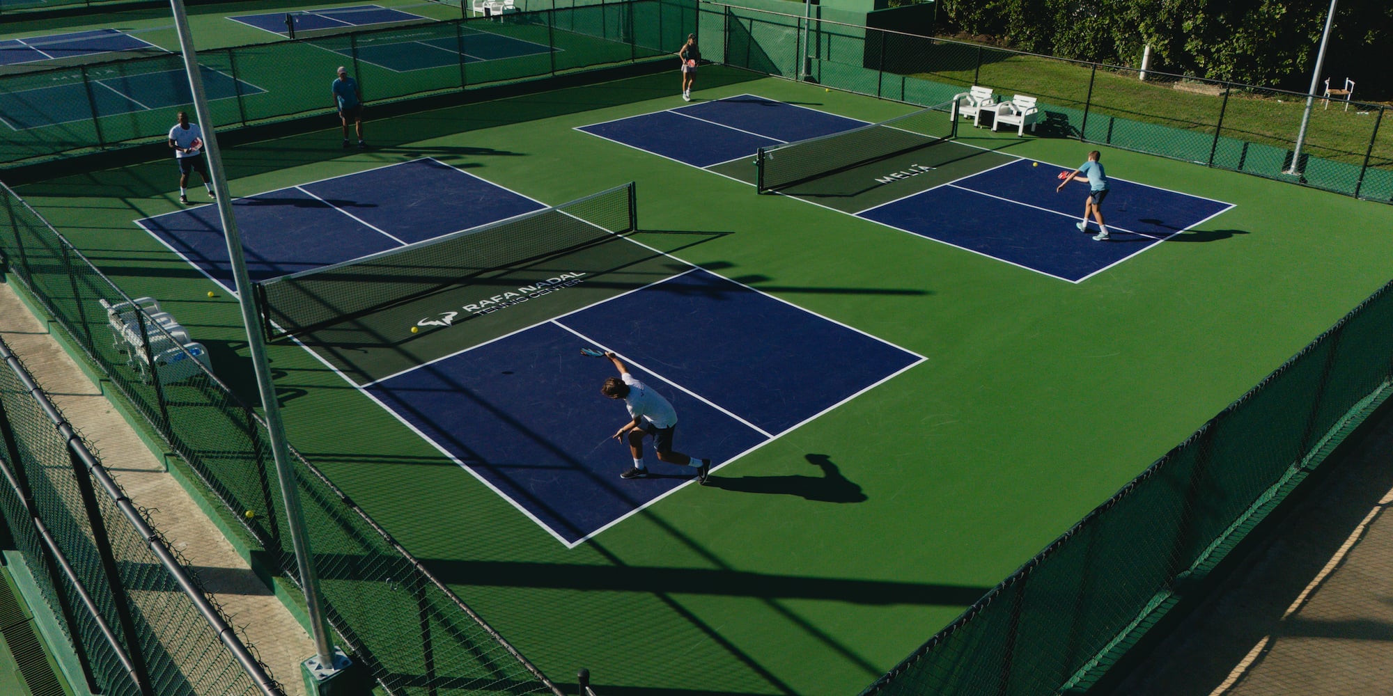 a group of people playing tennis