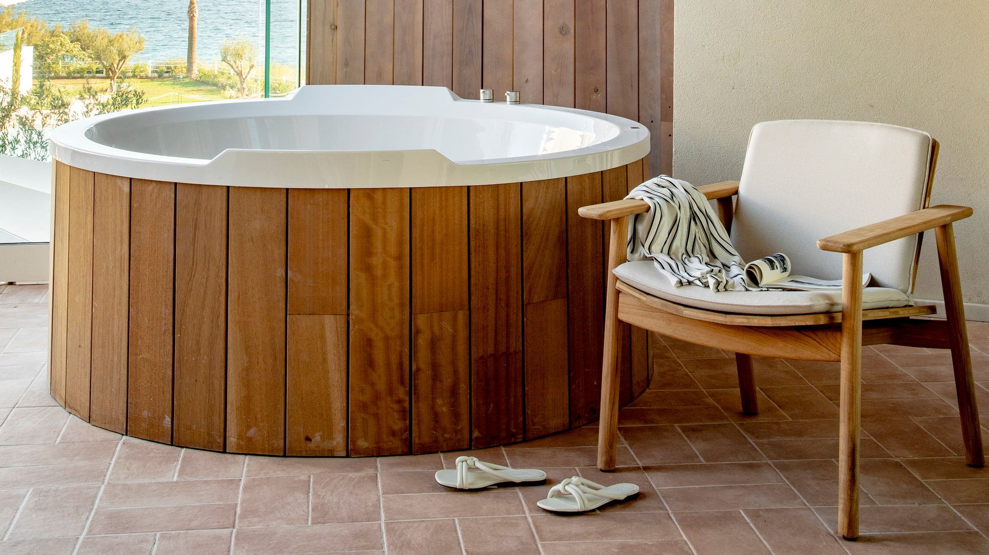 a hot tub with a chair and a chair on a deck