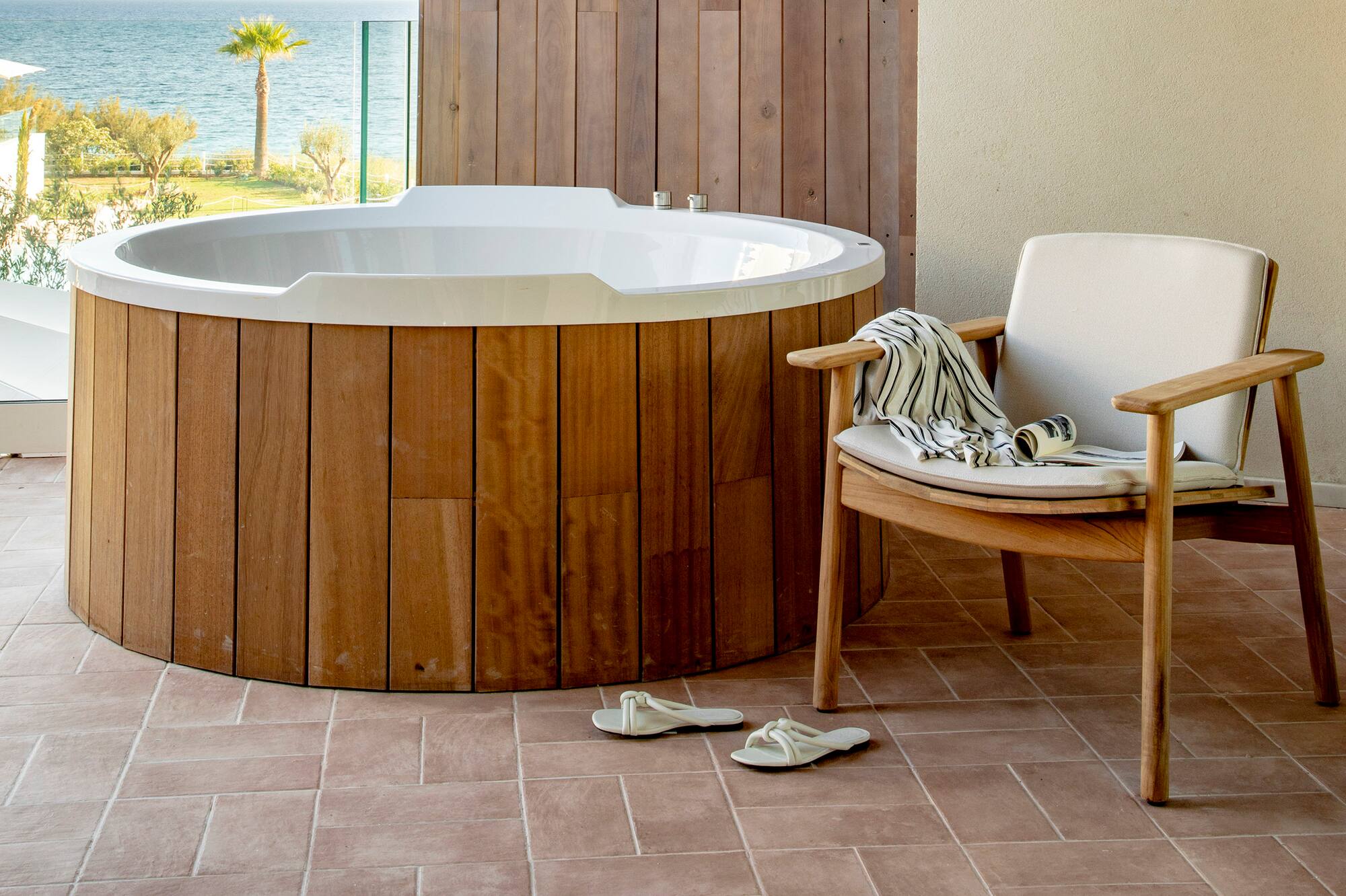 a hot tub with a chair and a chair on a deck