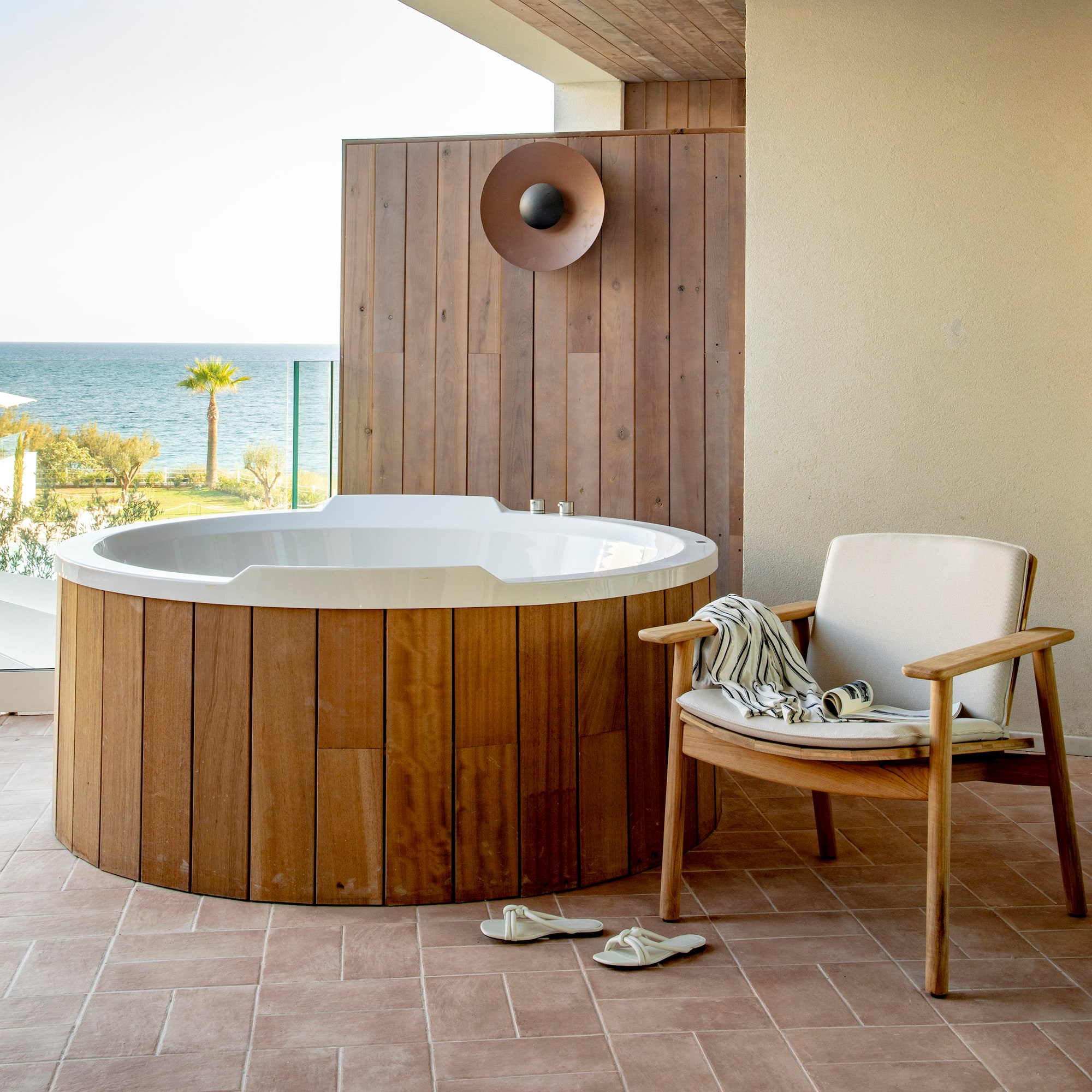 a hot tub with a chair and a chair on a deck