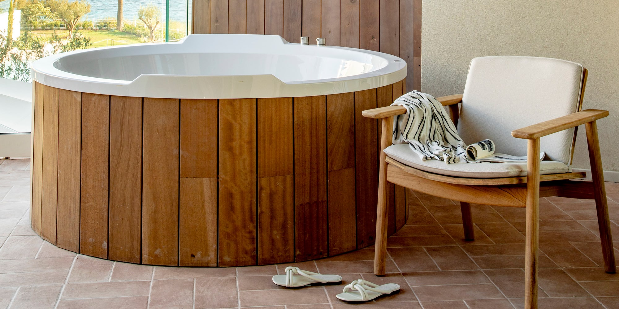 a hot tub with a chair and a chair on a deck