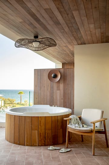 a hot tub with a chair and a chair on a deck