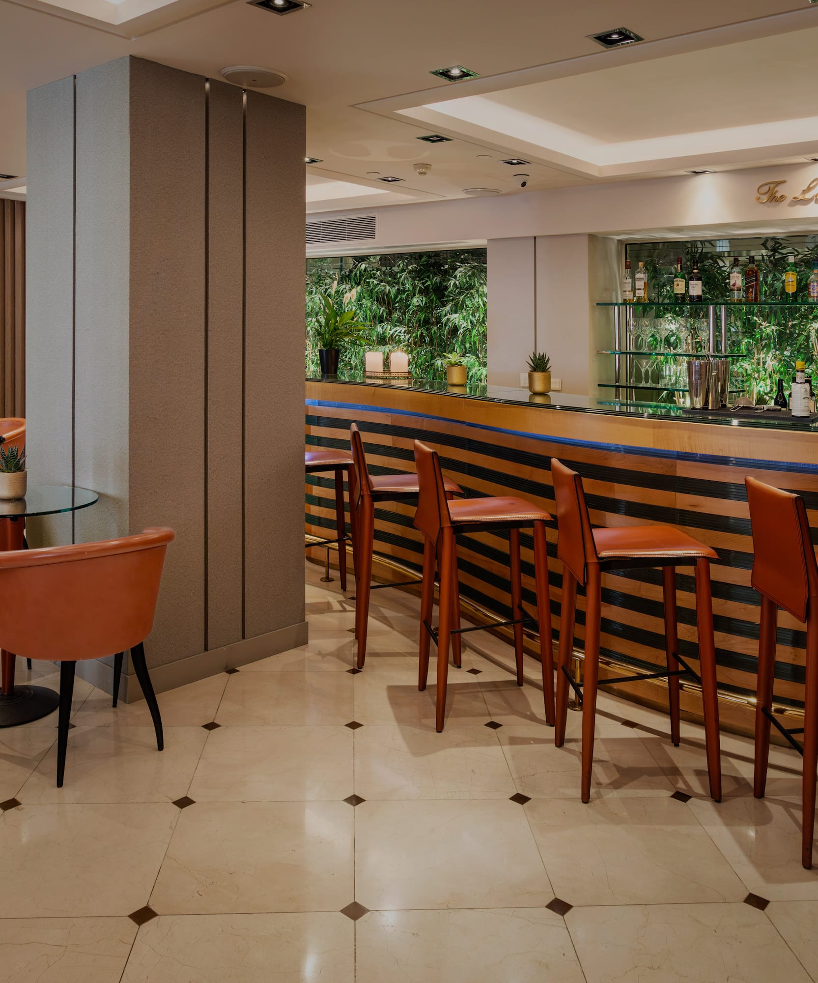 The Lobby Bar with orange bar stools, striped counter, and lounge seating.