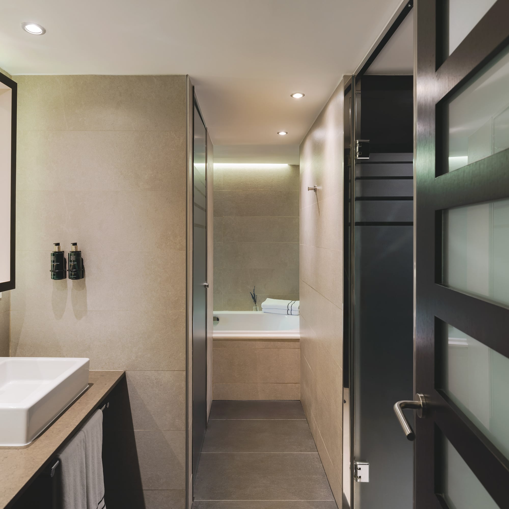 Baño moderno con lavabo doble, diseño contemporáneo y acceso a ducha/bañera.