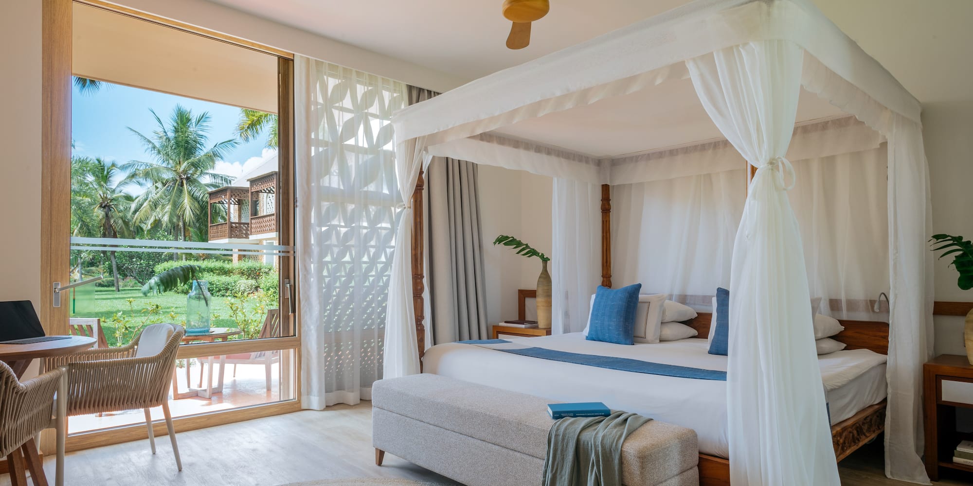 Fully Renovated Premium bedroom with a canopy bed and a bench at Melia Zanzibar with garden views