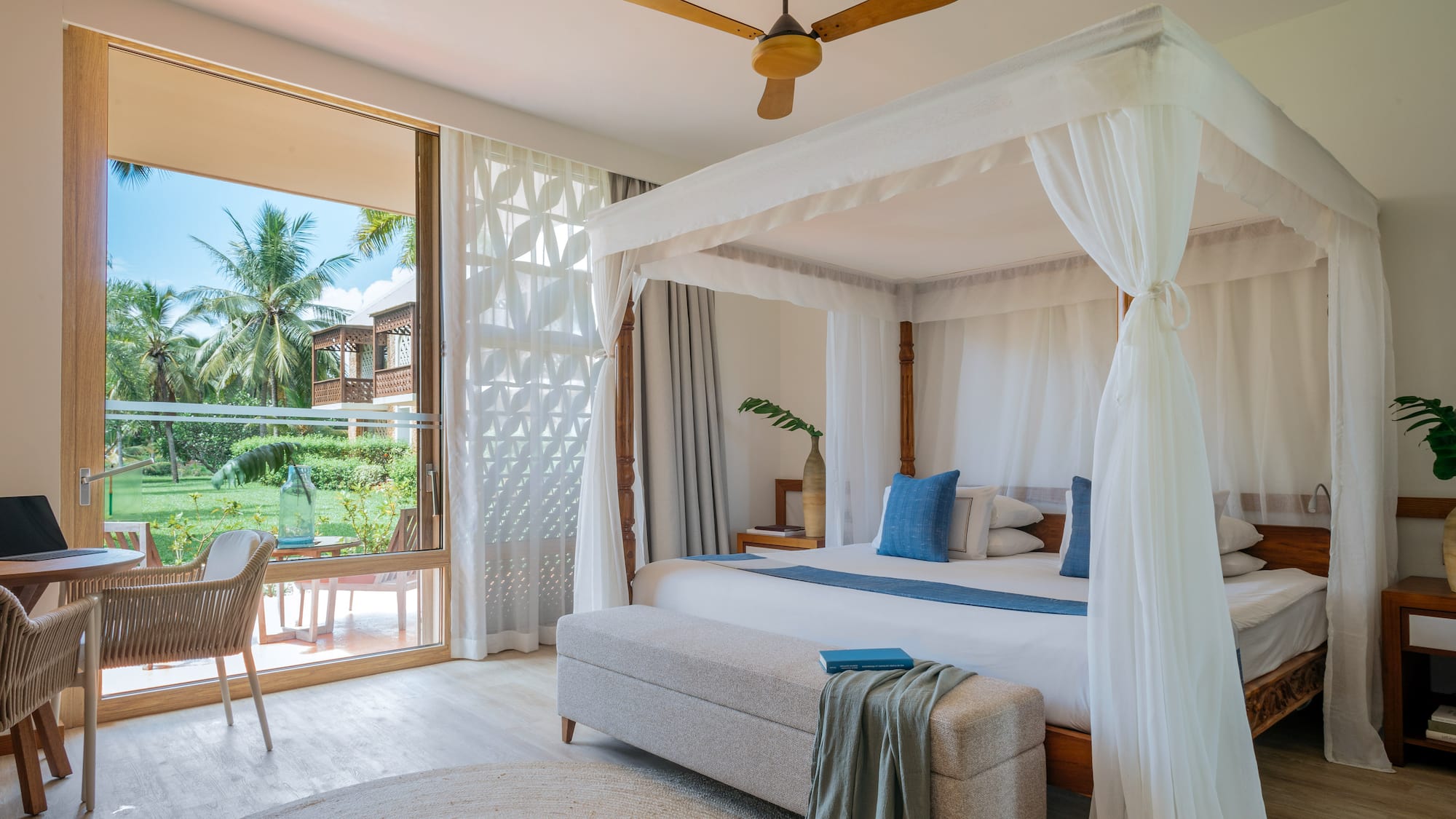 Fully Renovated Premium bedroom with a canopy bed and a bench at Melia Zanzibar with garden views