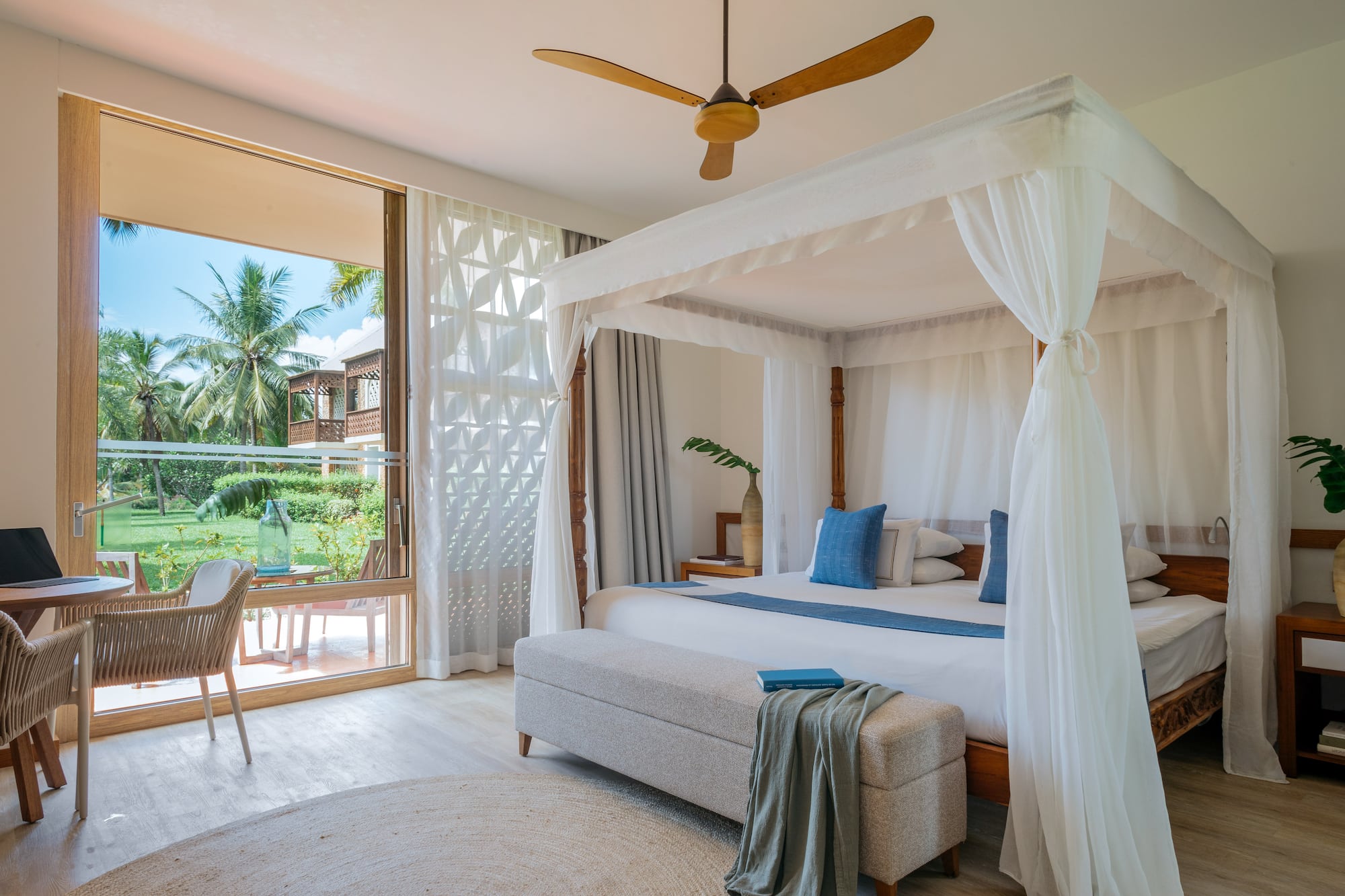 Fully Renovated Premium bedroom with a canopy bed and a bench at Melia Zanzibar with garden views
