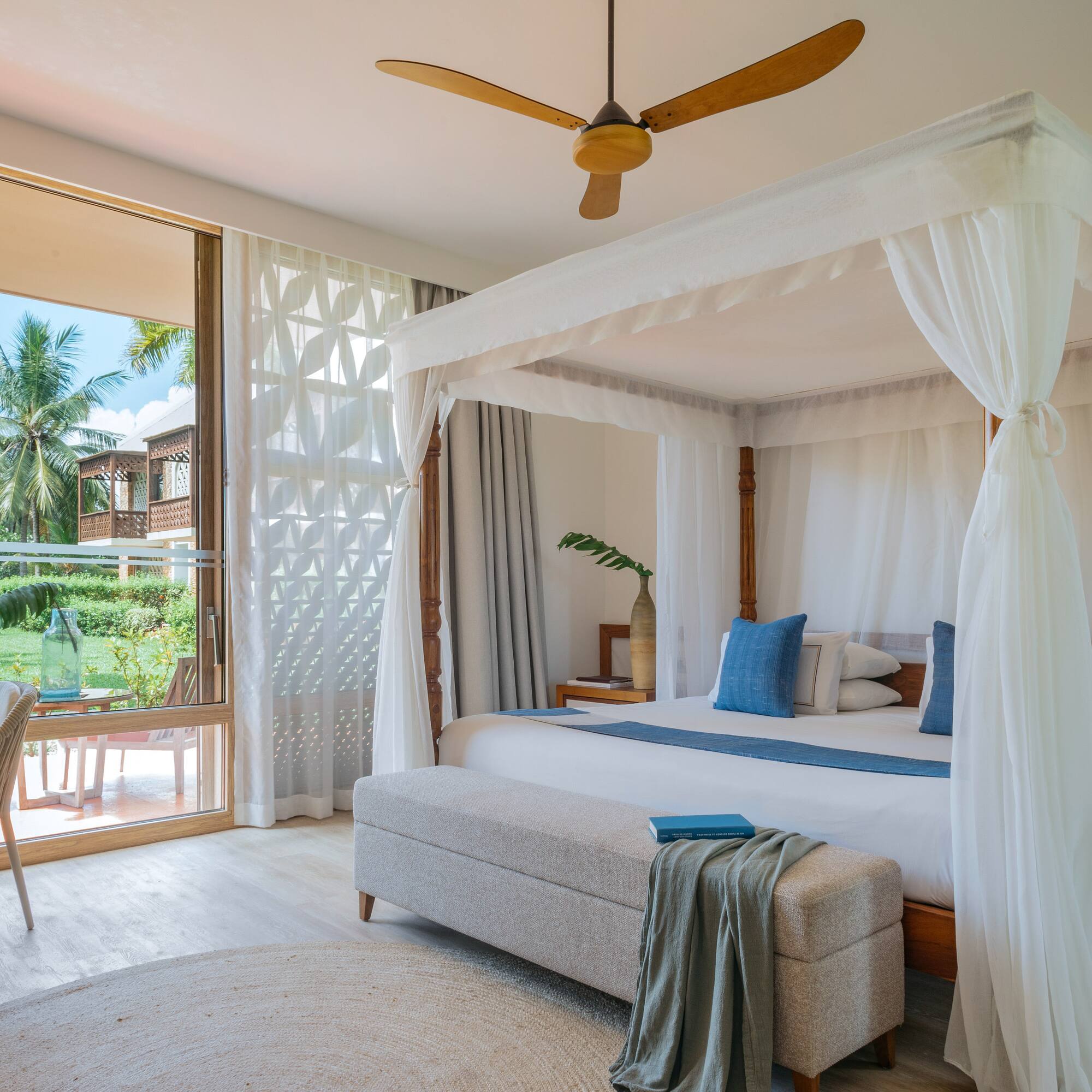 Fully Renovated Premium bedroom with a canopy bed and a bench at Melia Zanzibar with garden views