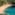a beach with blue water and trees
