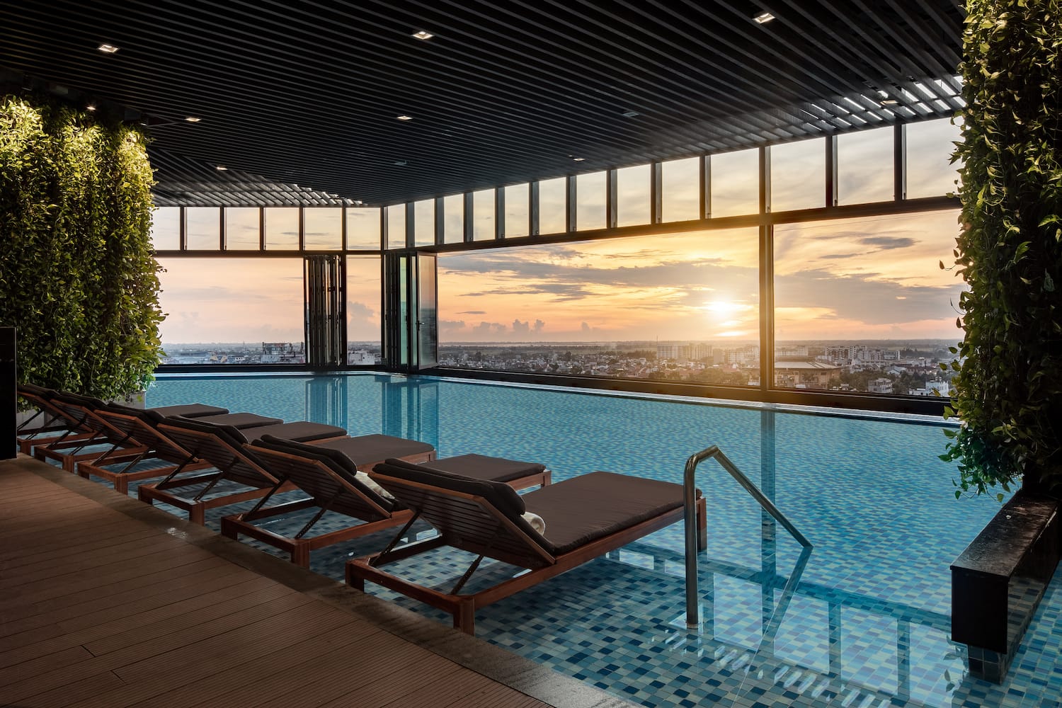 a pool with chairs and a view of the city