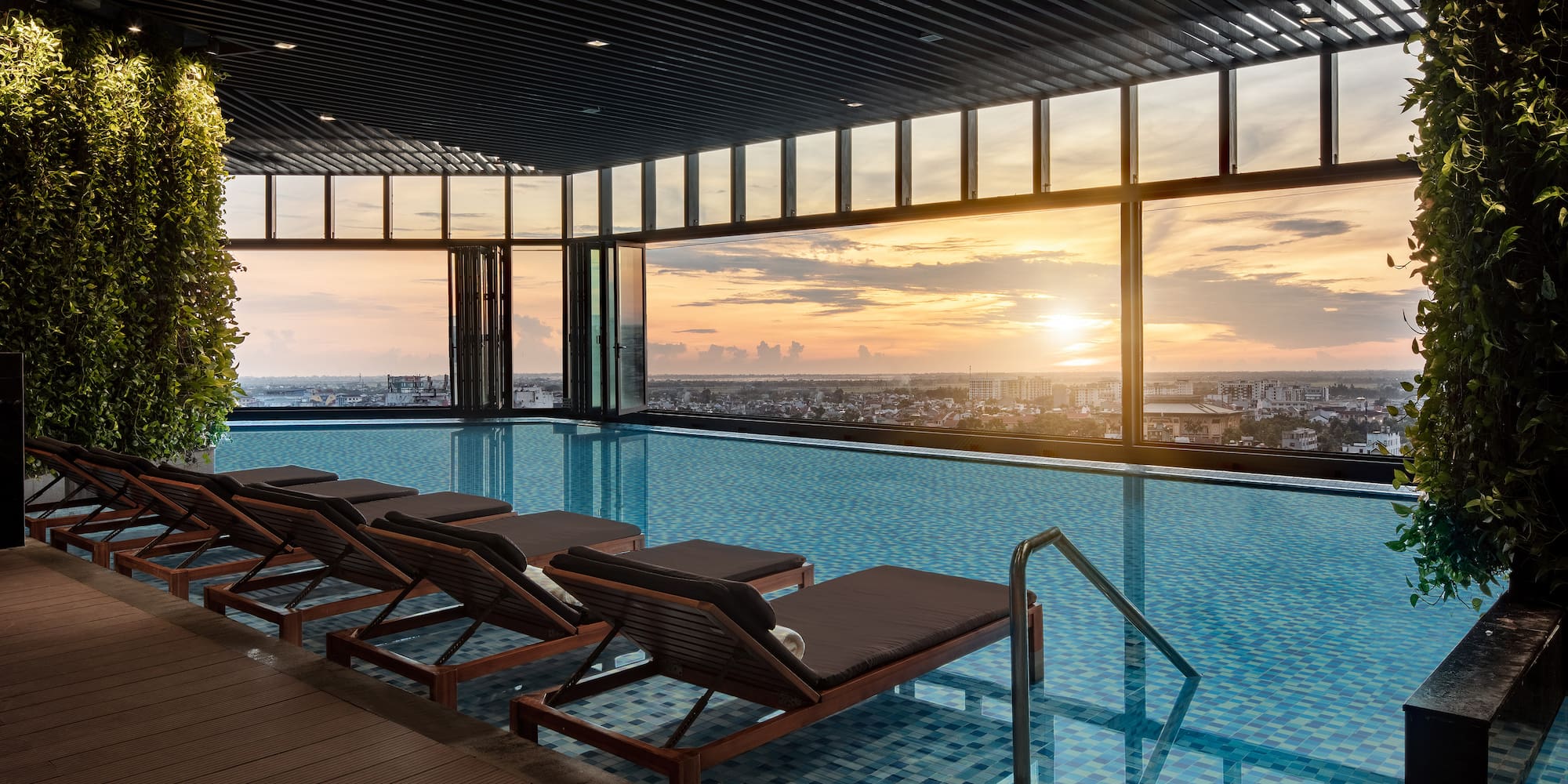 a pool with chairs and a view of the city
