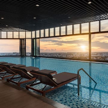 a pool with chairs and a view of the city