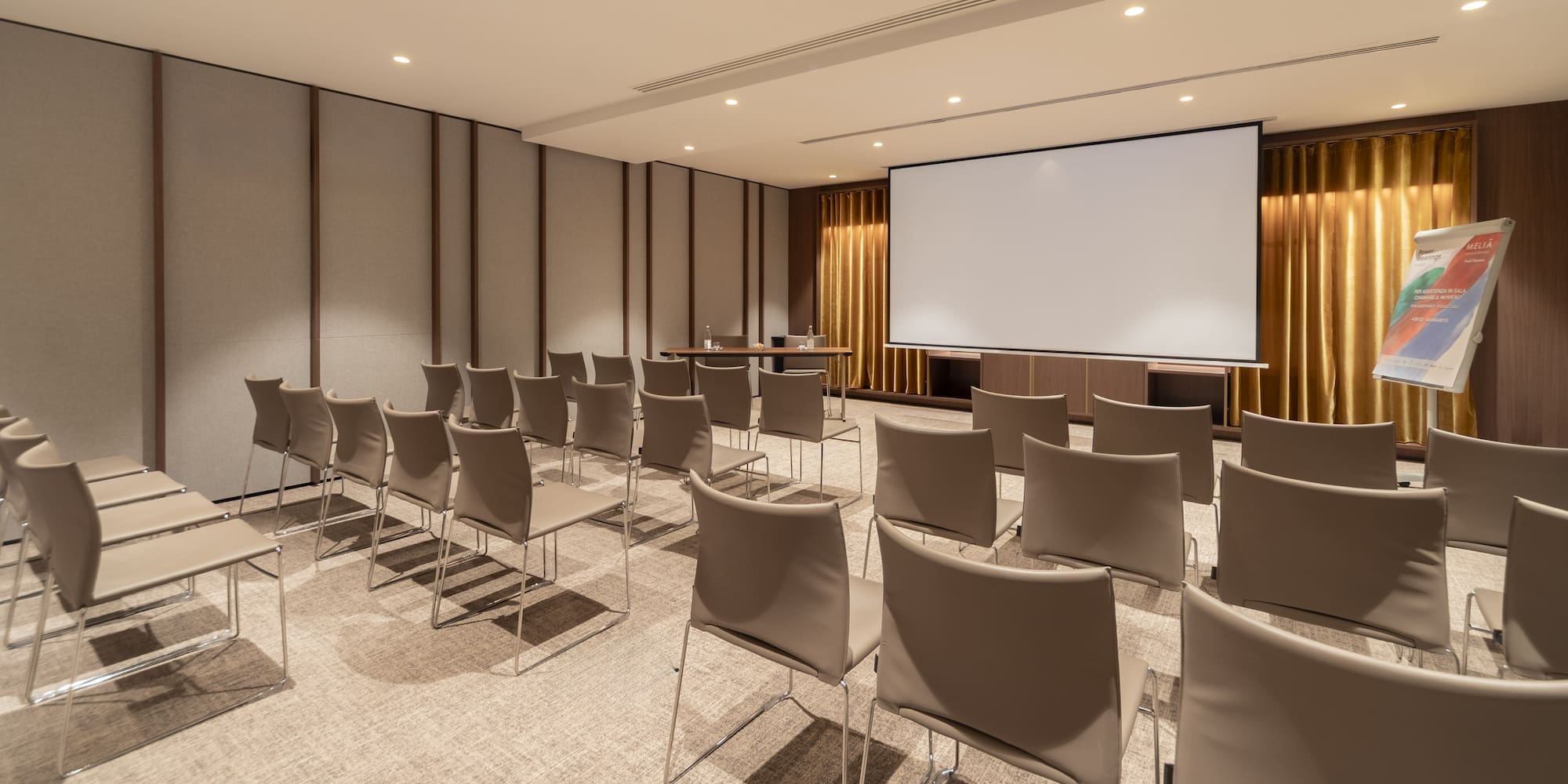 a room with chairs and a projector screen