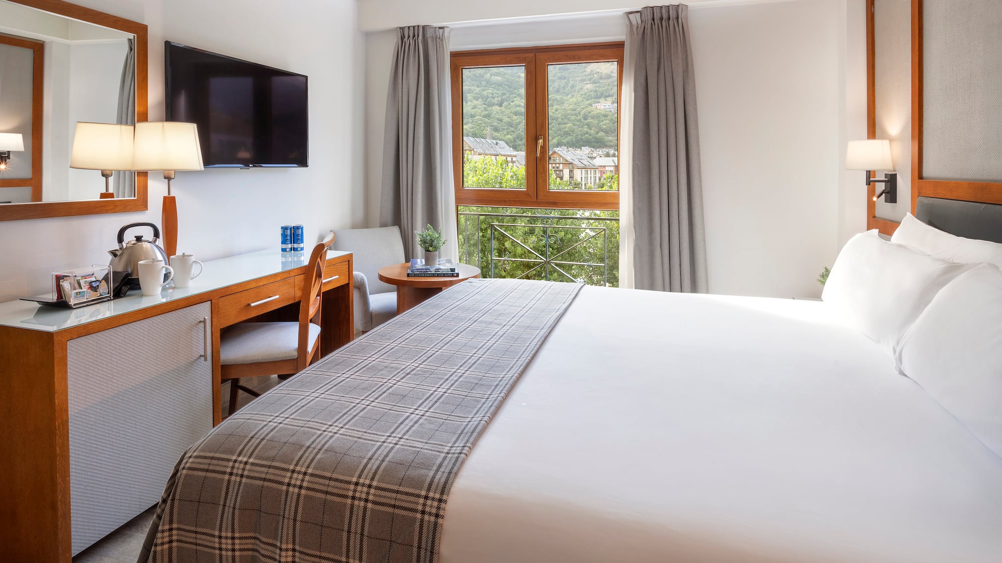 a bedroom with a bed and a desk and a television