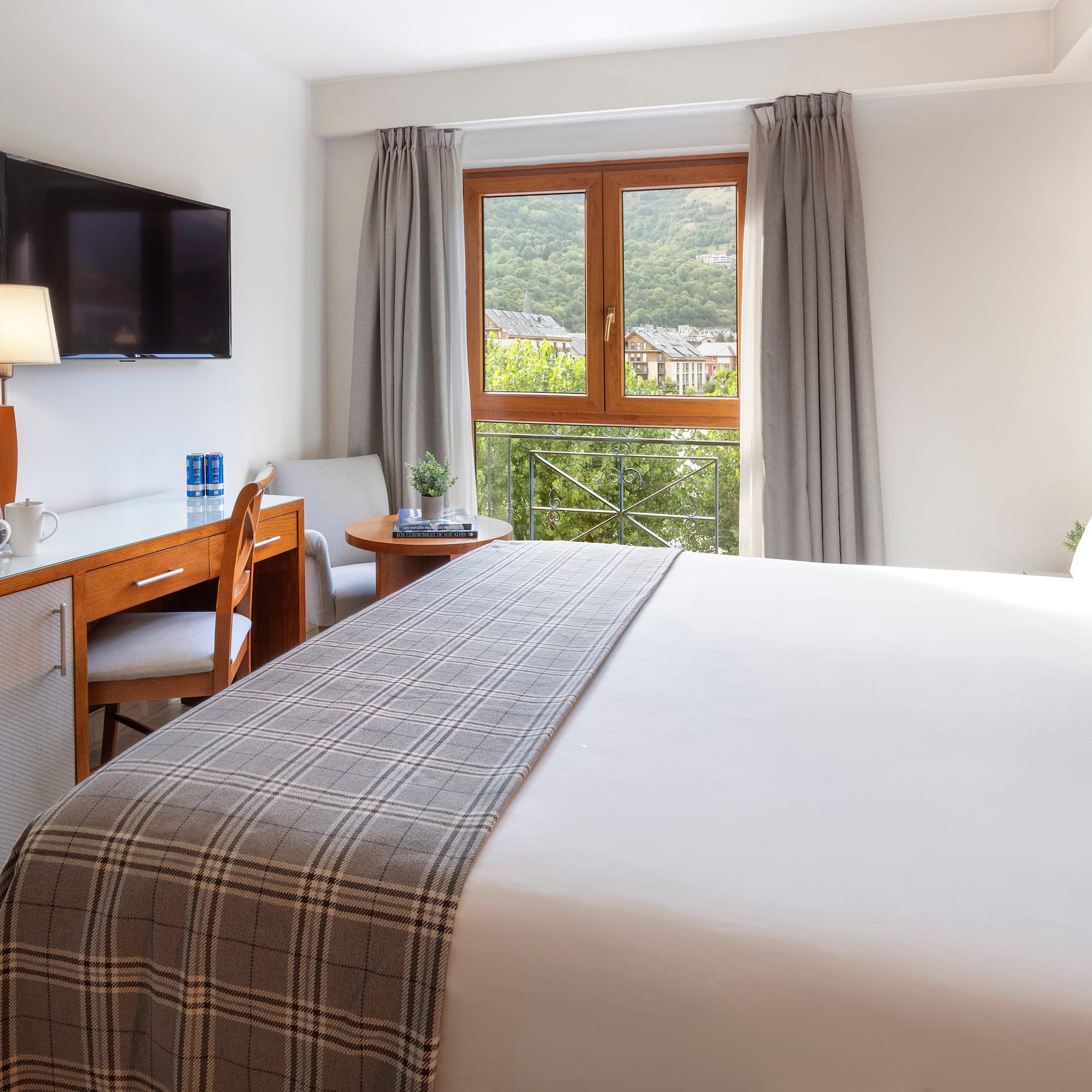 a bedroom with a bed and a desk and a television