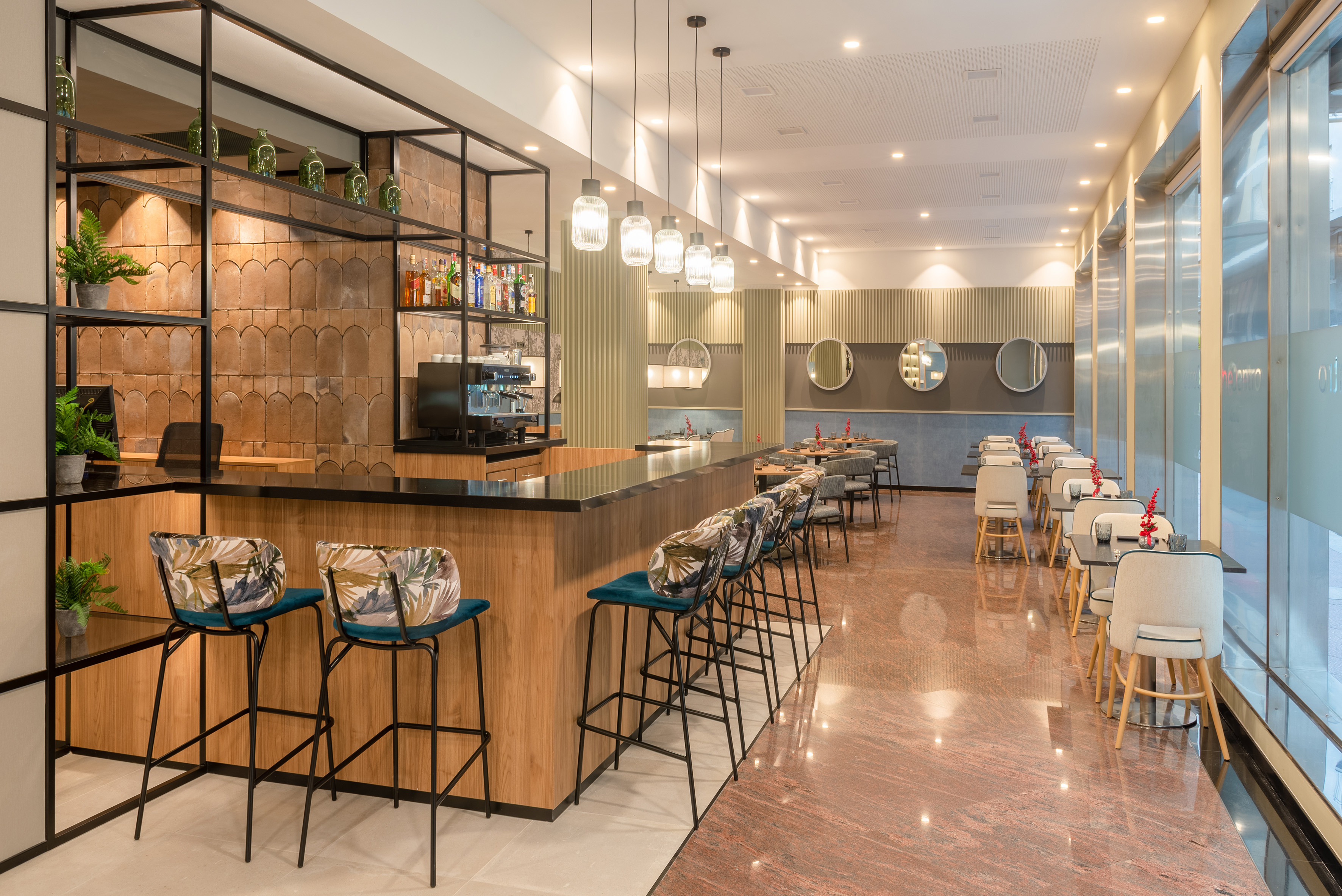 Modern restaurant interior with a sleek bar, stools, and dining tables.