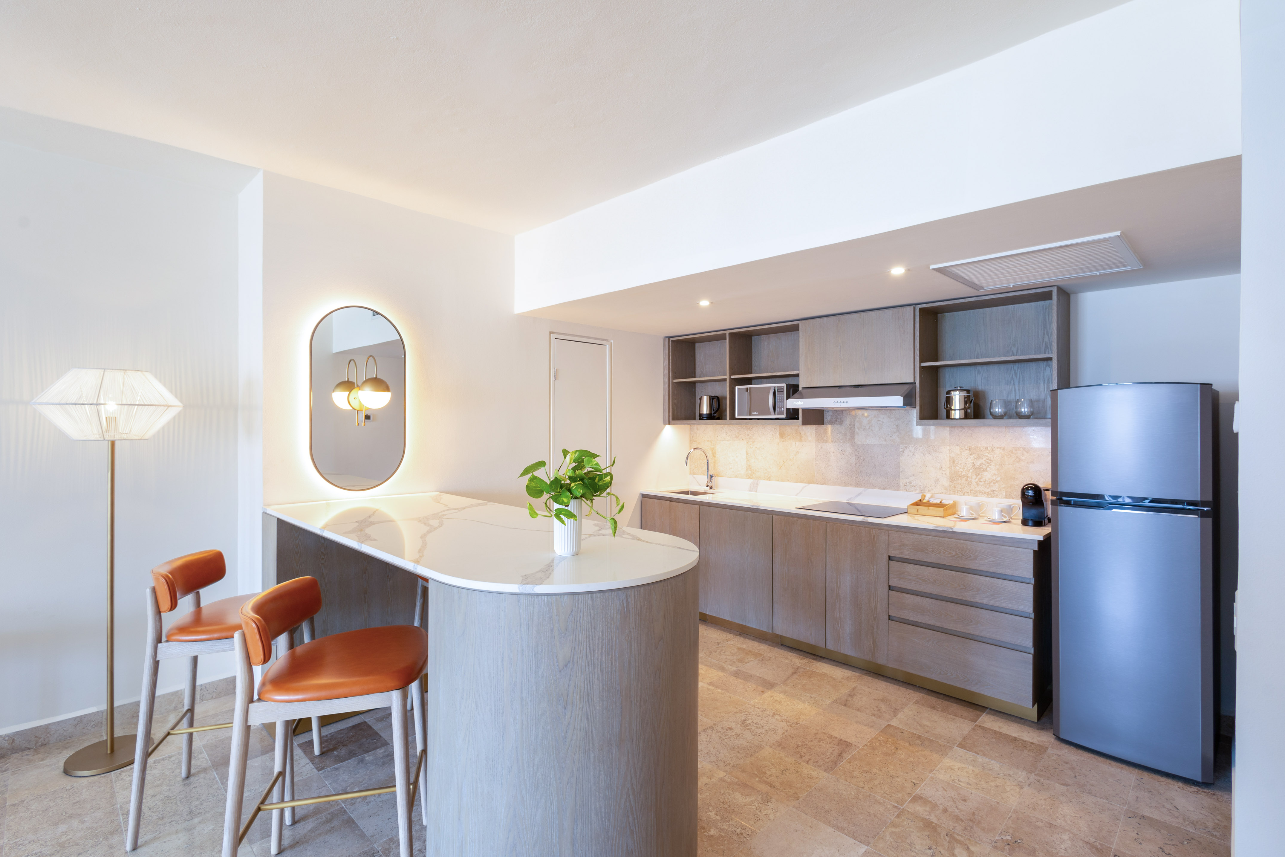 Contemporary studio kitchen with wood cabinets, marble island, bar seating.