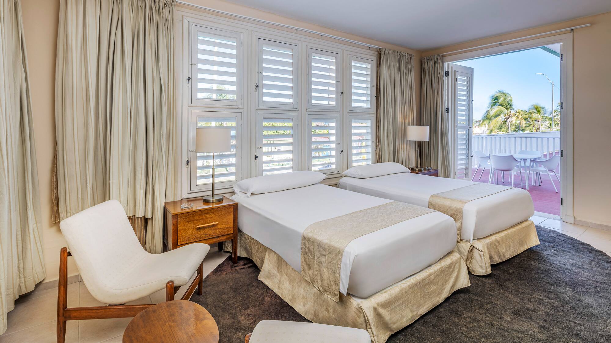 a room with two beds and chairs