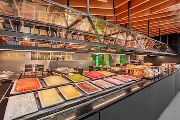 Modern hotel buffet featuring fresh fruit, cheeses, charcuterie, and bread.