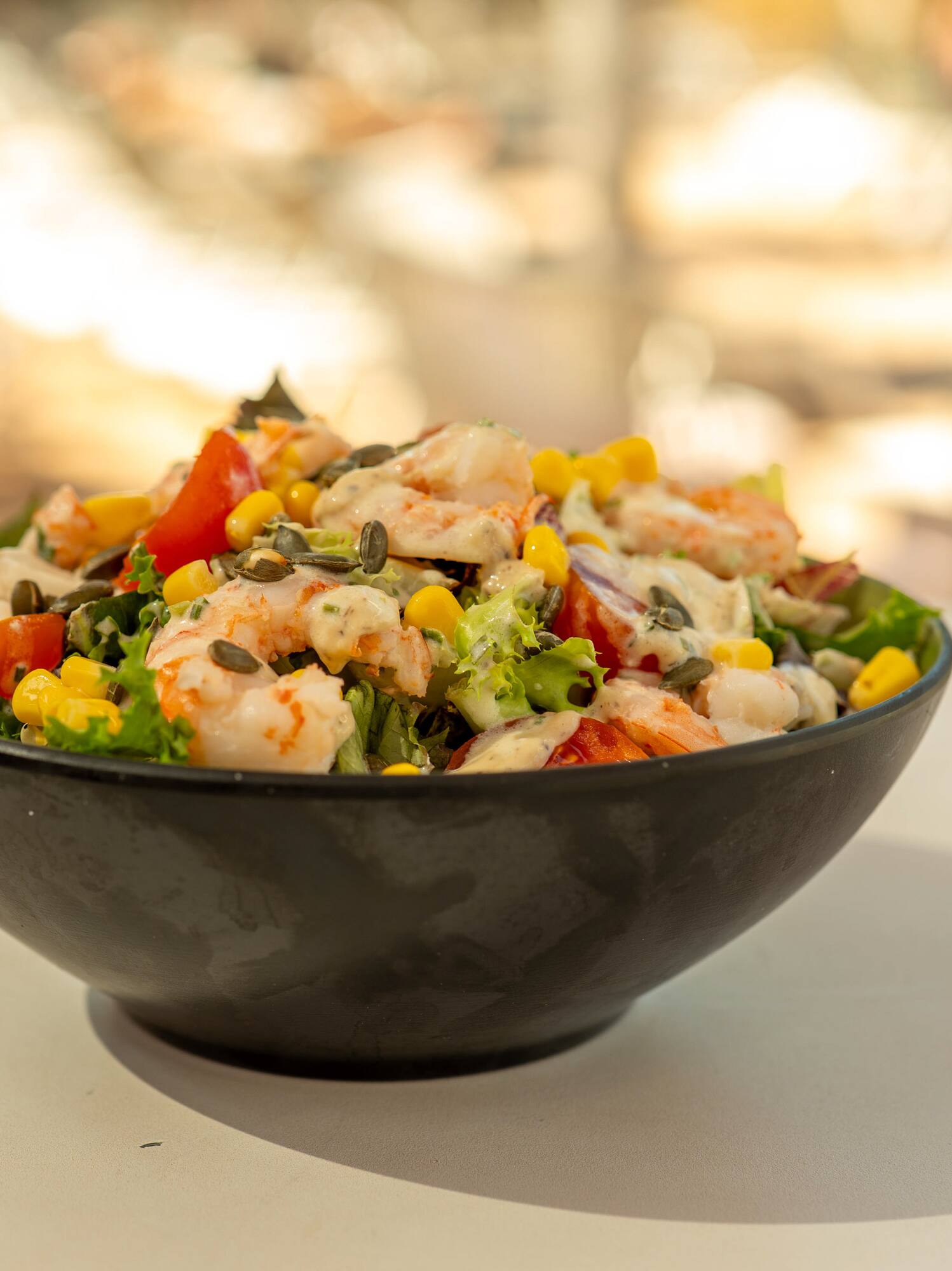 Fresh shrimp salad with corn, tomatoes, seeds, and creamy dressing.