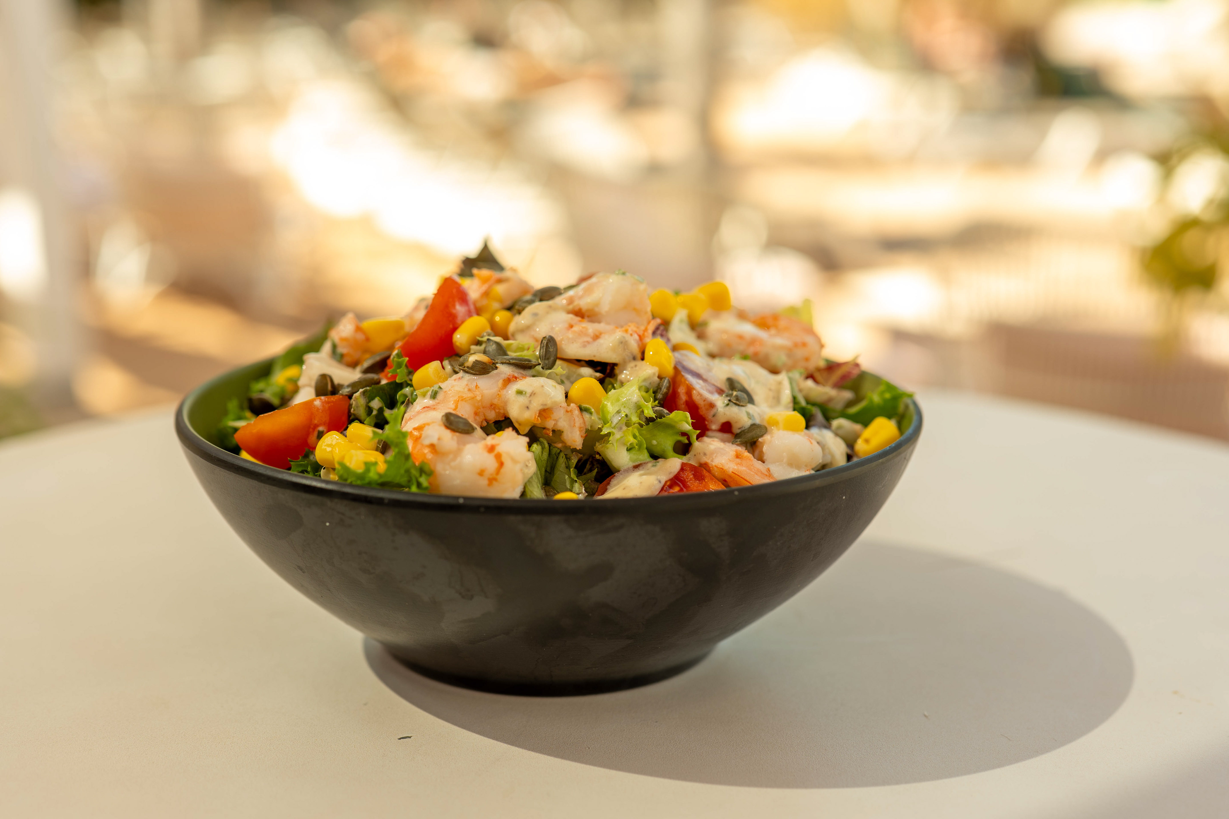 Fresh shrimp salad with corn, tomatoes, seeds, and creamy dressing.