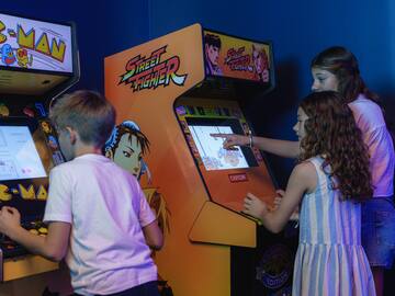 a group of kids playing arcade games