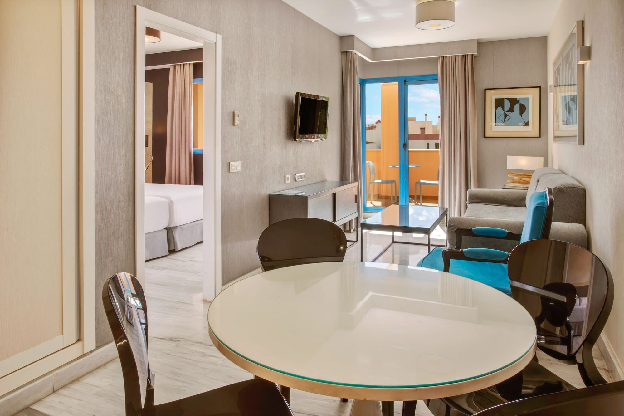 Modern hotel apartment living room, dining table, sofa, and balcony.