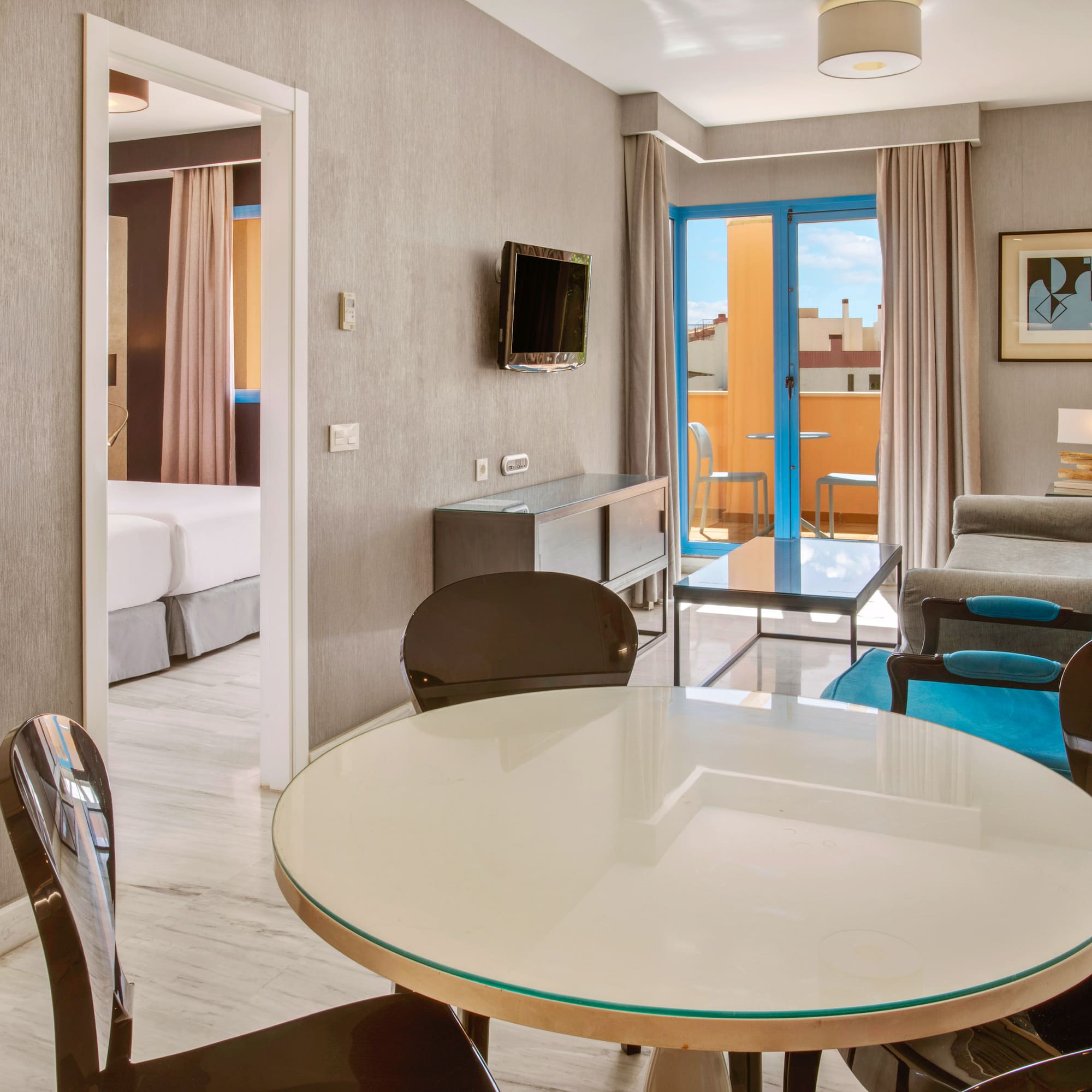 Modern hotel apartment living room, dining table, sofa, and balcony.