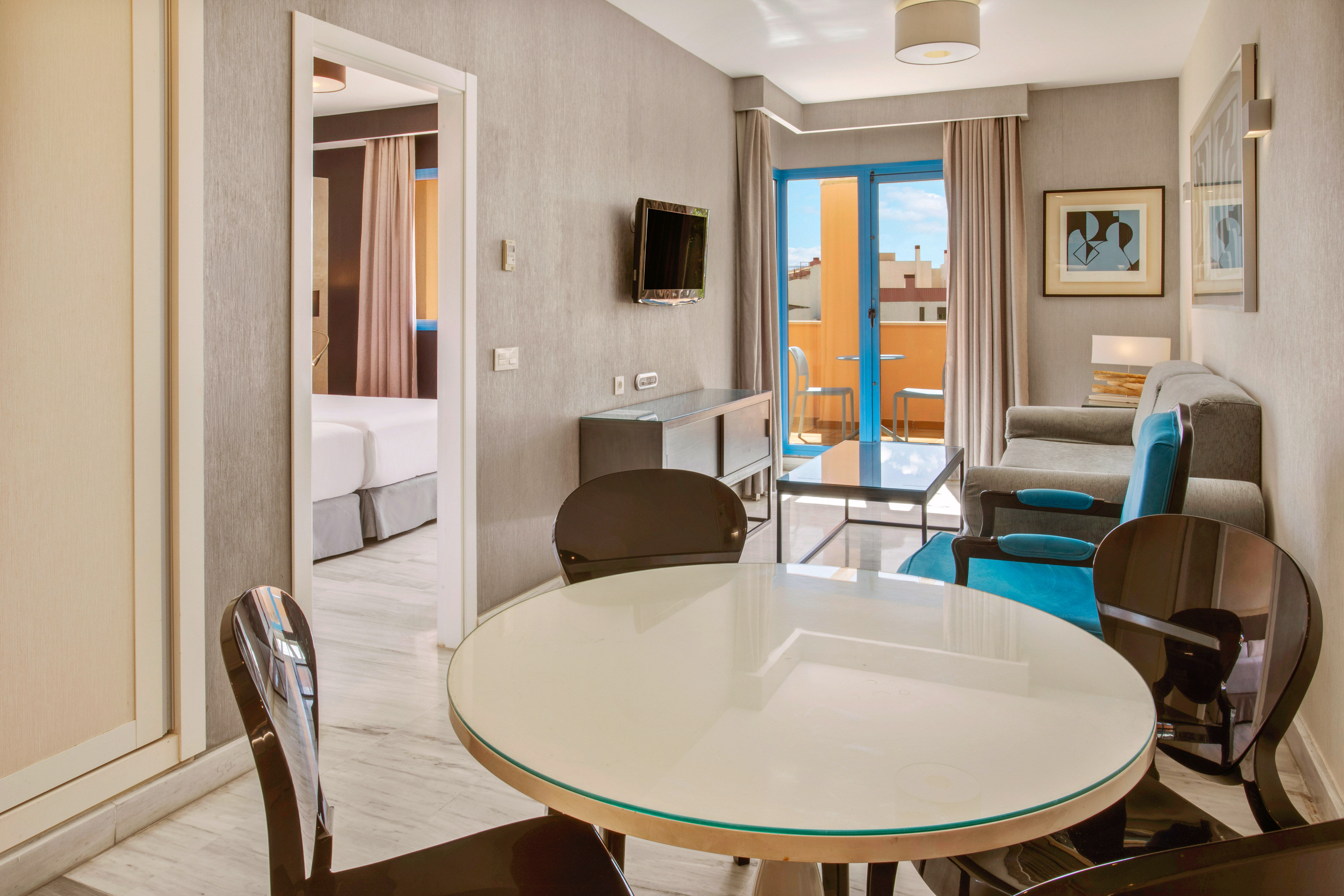 Modern hotel apartment living room, dining table, sofa, and balcony.
