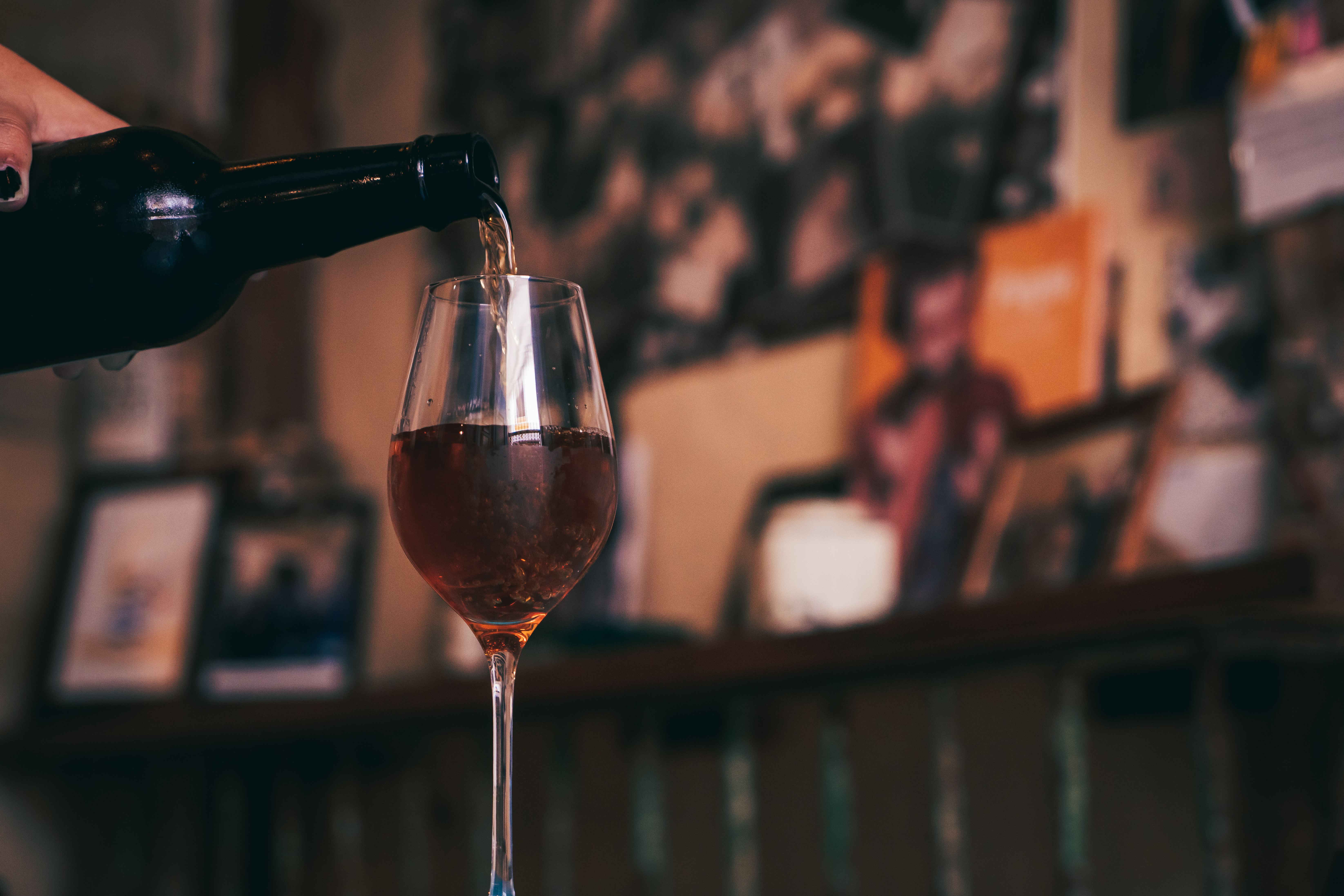 a glass of wine being poured into a glass