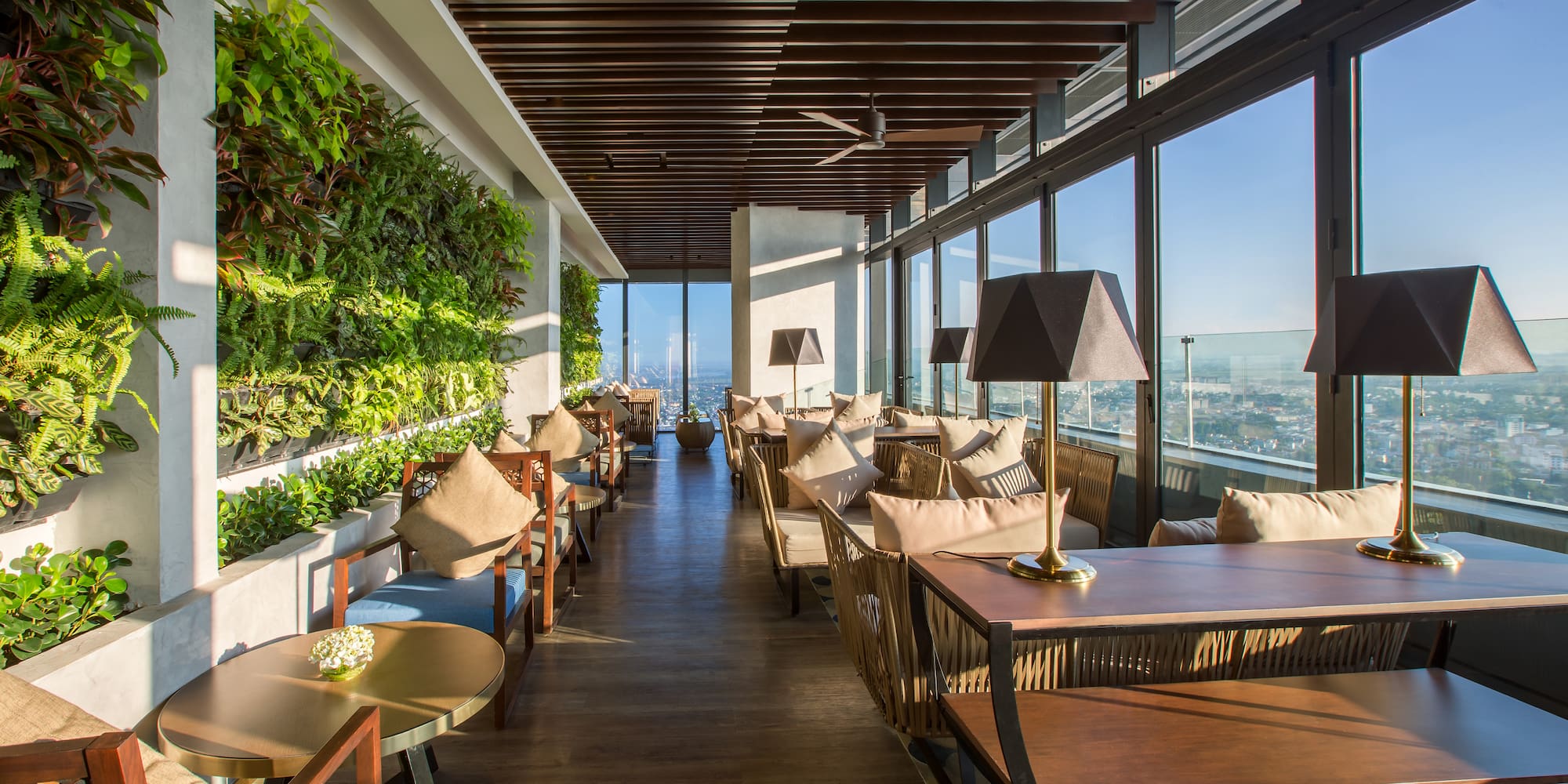 a room with tables and chairs and plants on the wall