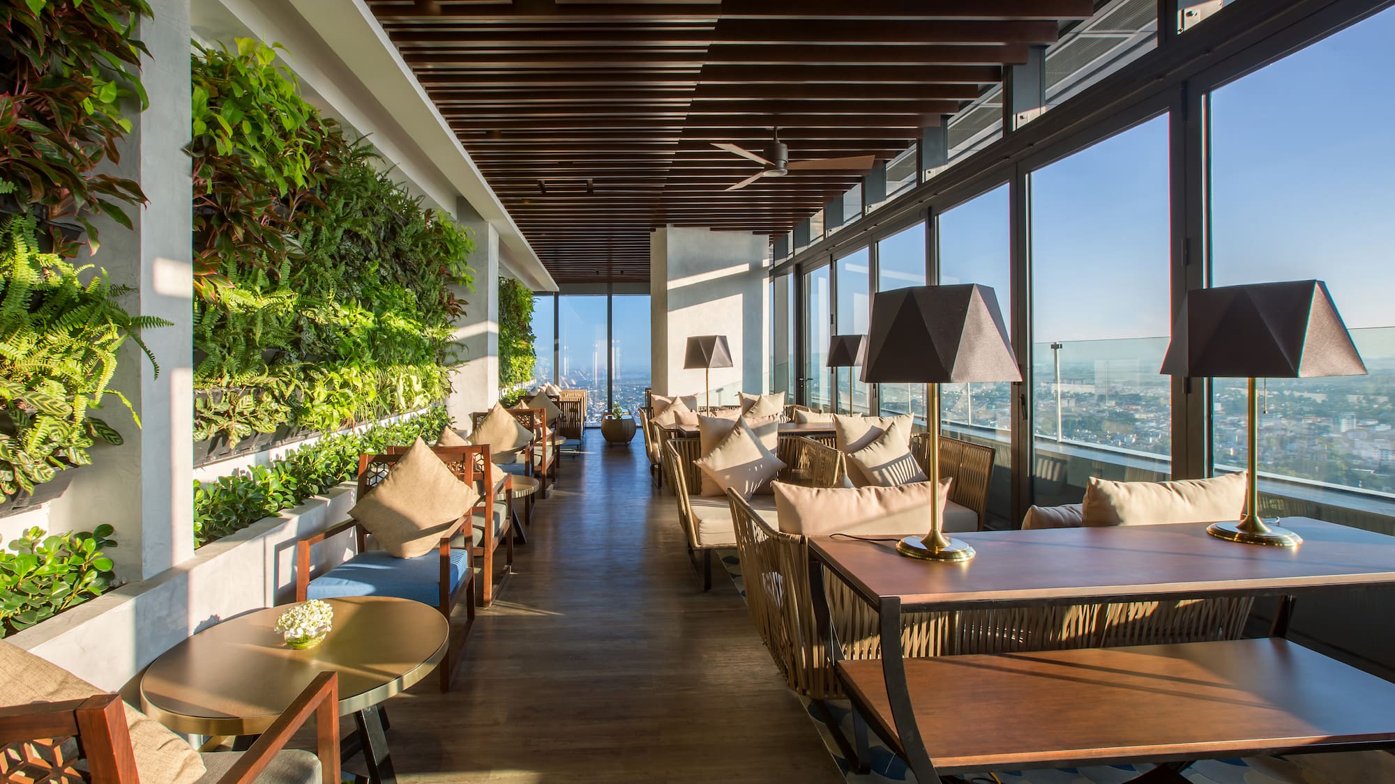 a room with tables and chairs and plants on the wall