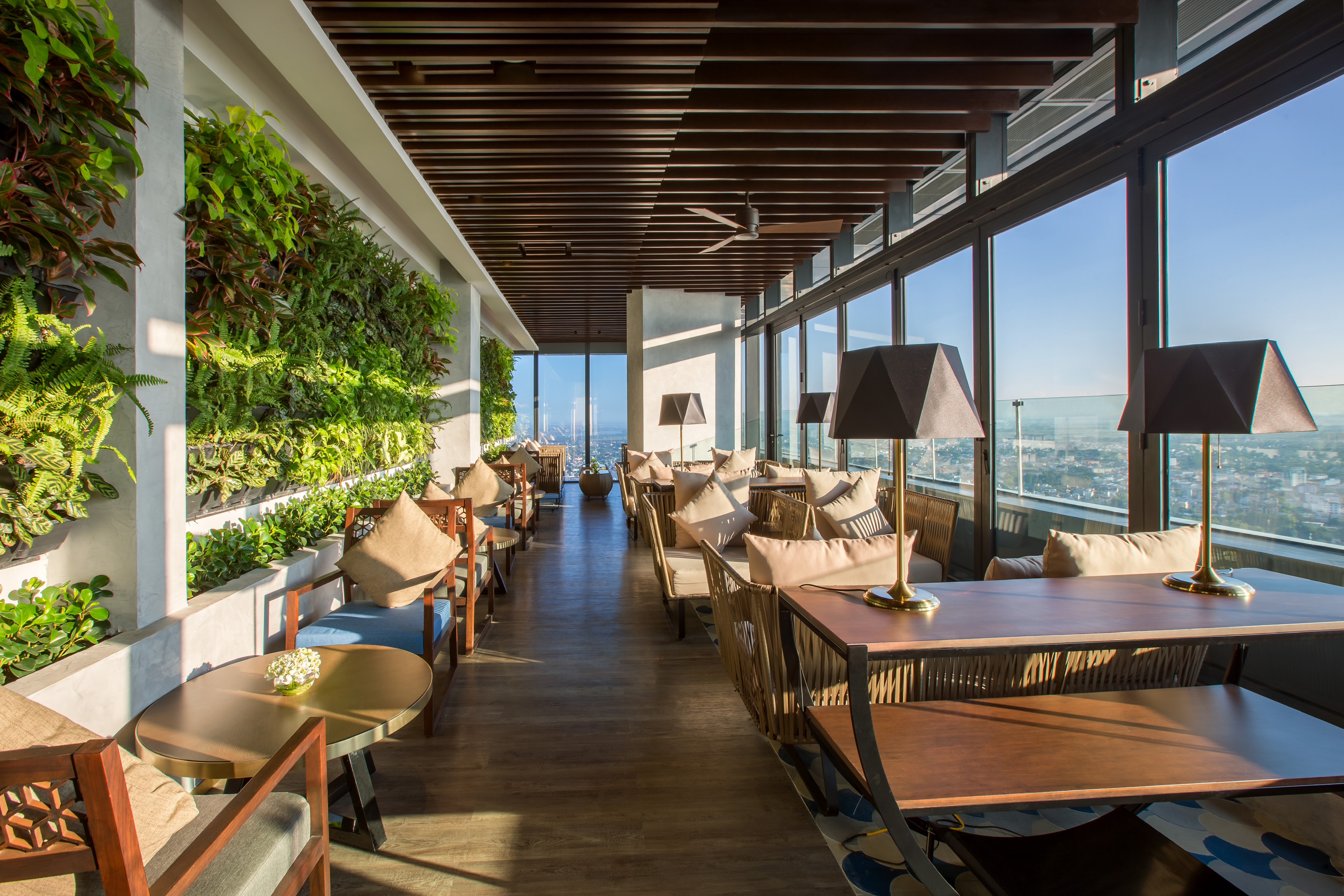 a room with tables and chairs and plants on the wall