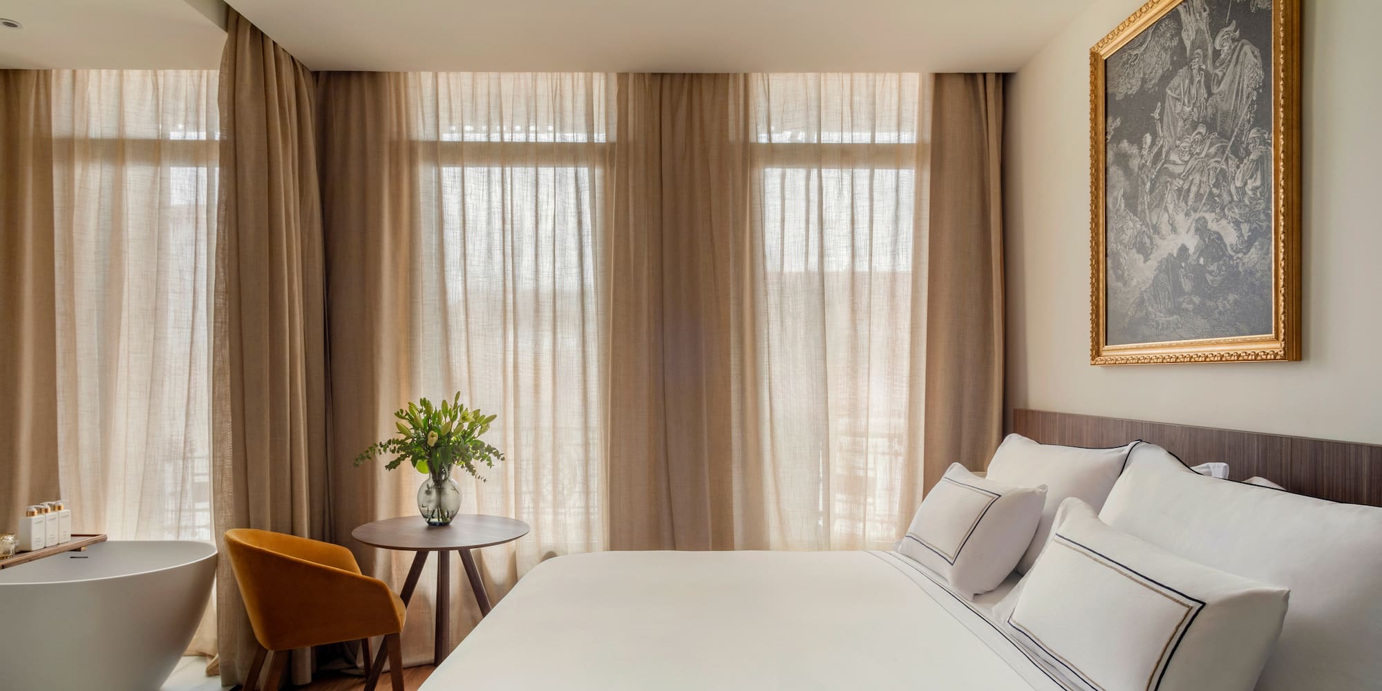 a bed with a table and chair in a room with curtains