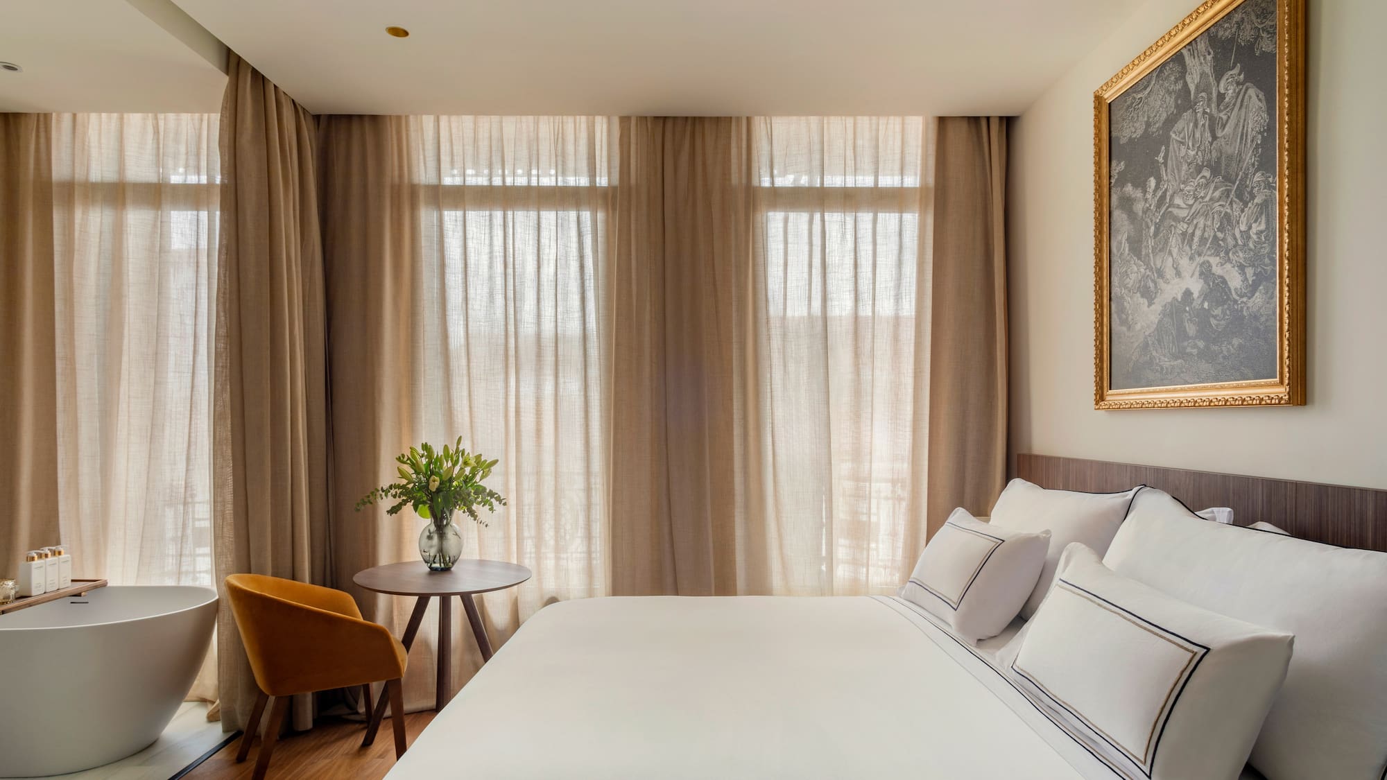 a bed with a table and chair in a room with curtains