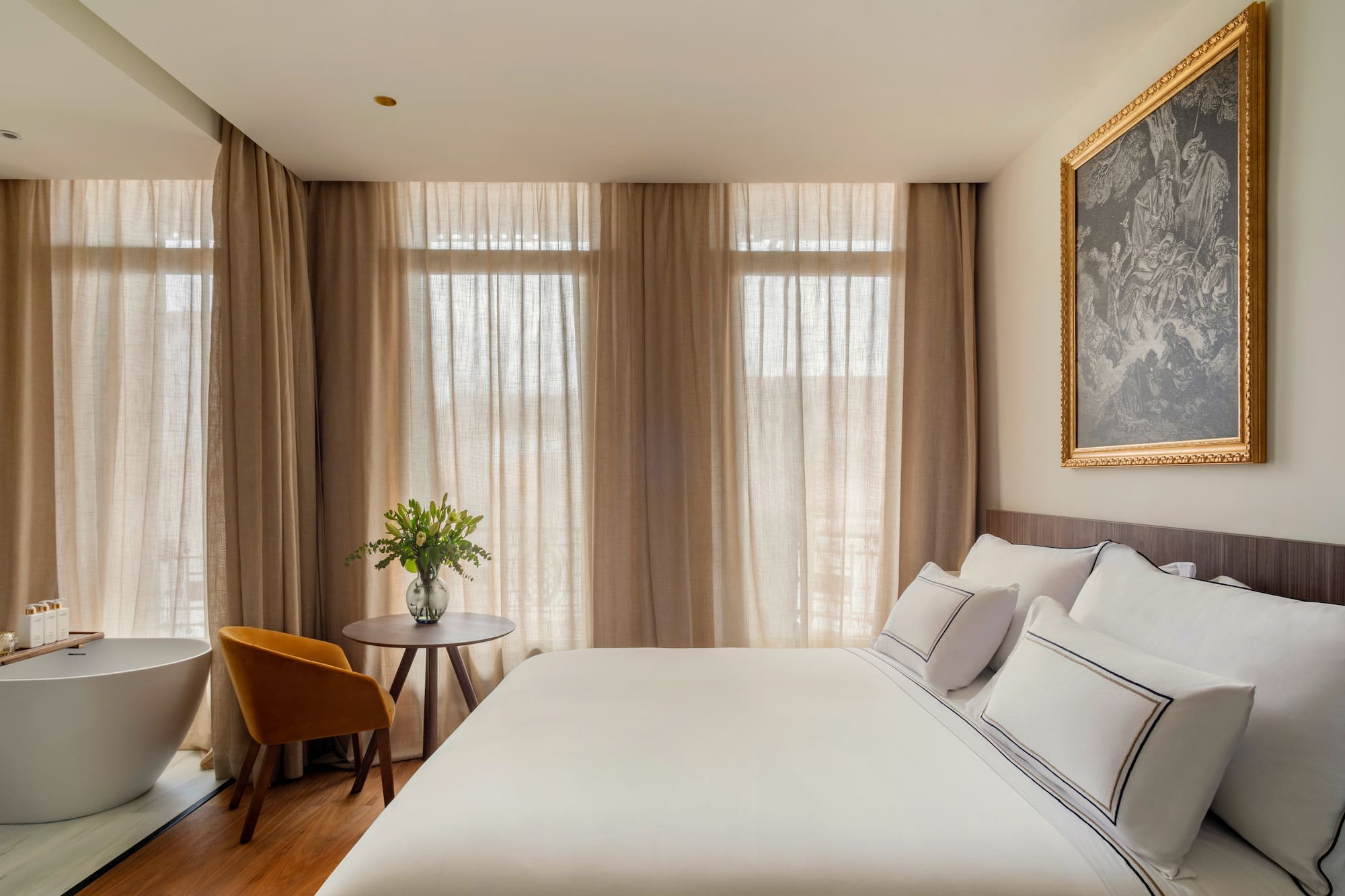 a bed with a table and chair in a room with curtains