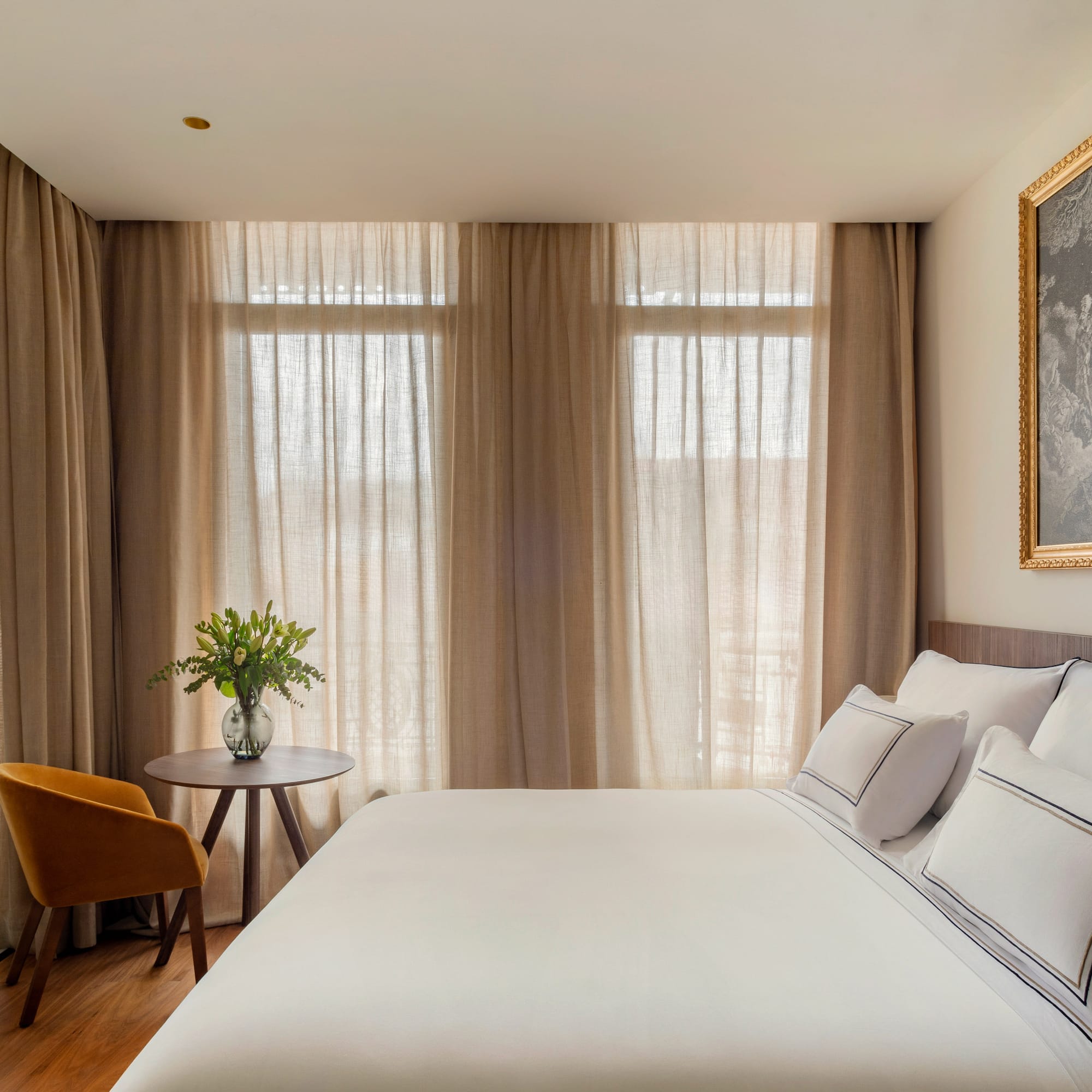 a bed with a table and chair in a room with curtains