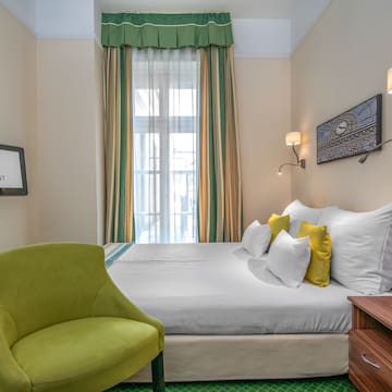 a room with a bed and a green chair